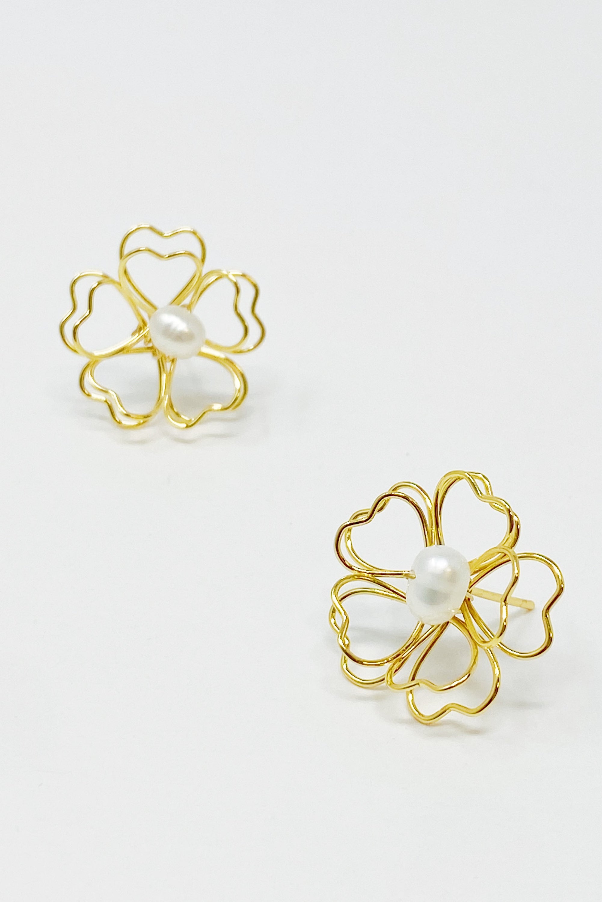 Elegant Heart Petals earrings featuring a freshwater pearl centerpiece and golden wire design.