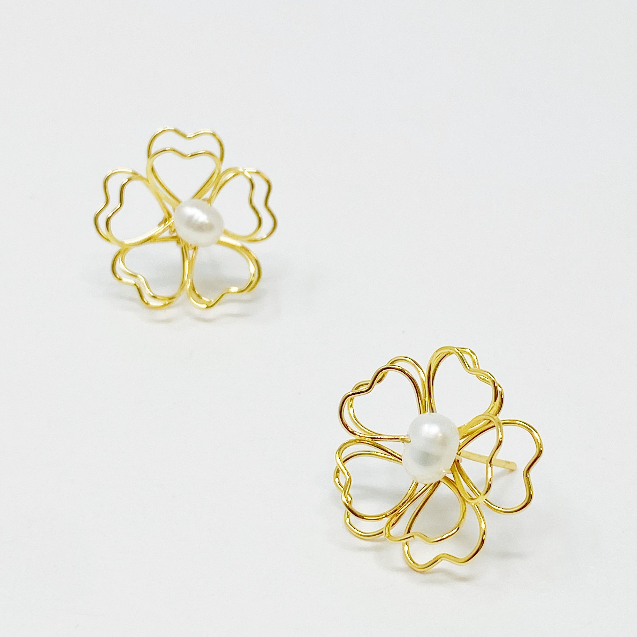 Elegant Heart Petals earrings featuring a freshwater pearl centerpiece and golden wire design.