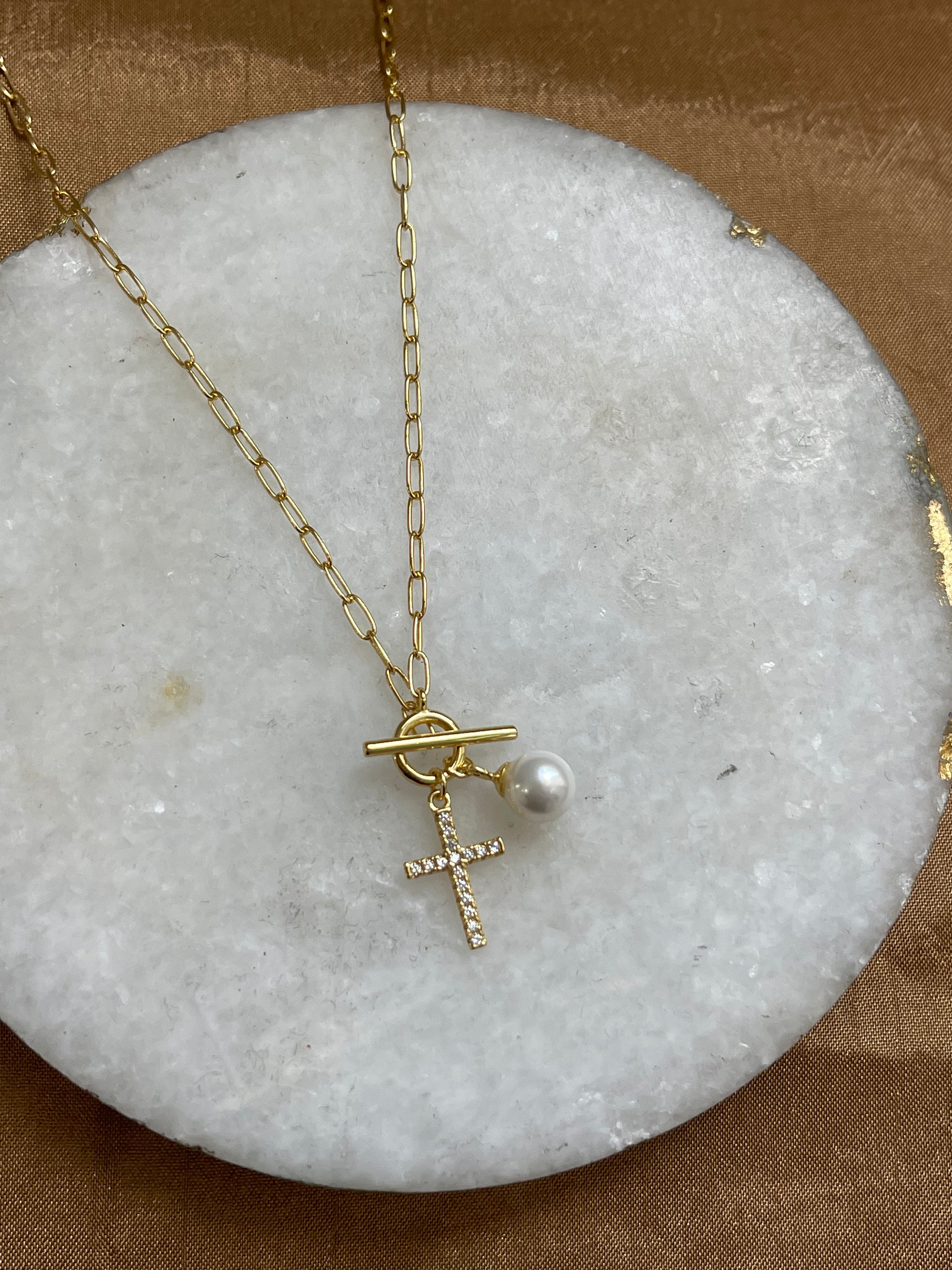 A delicate 17.5-inch Hope Necklace featuring a stylish cross design, plated in 18K gold, showcasing its dainty and meaningful appearance.