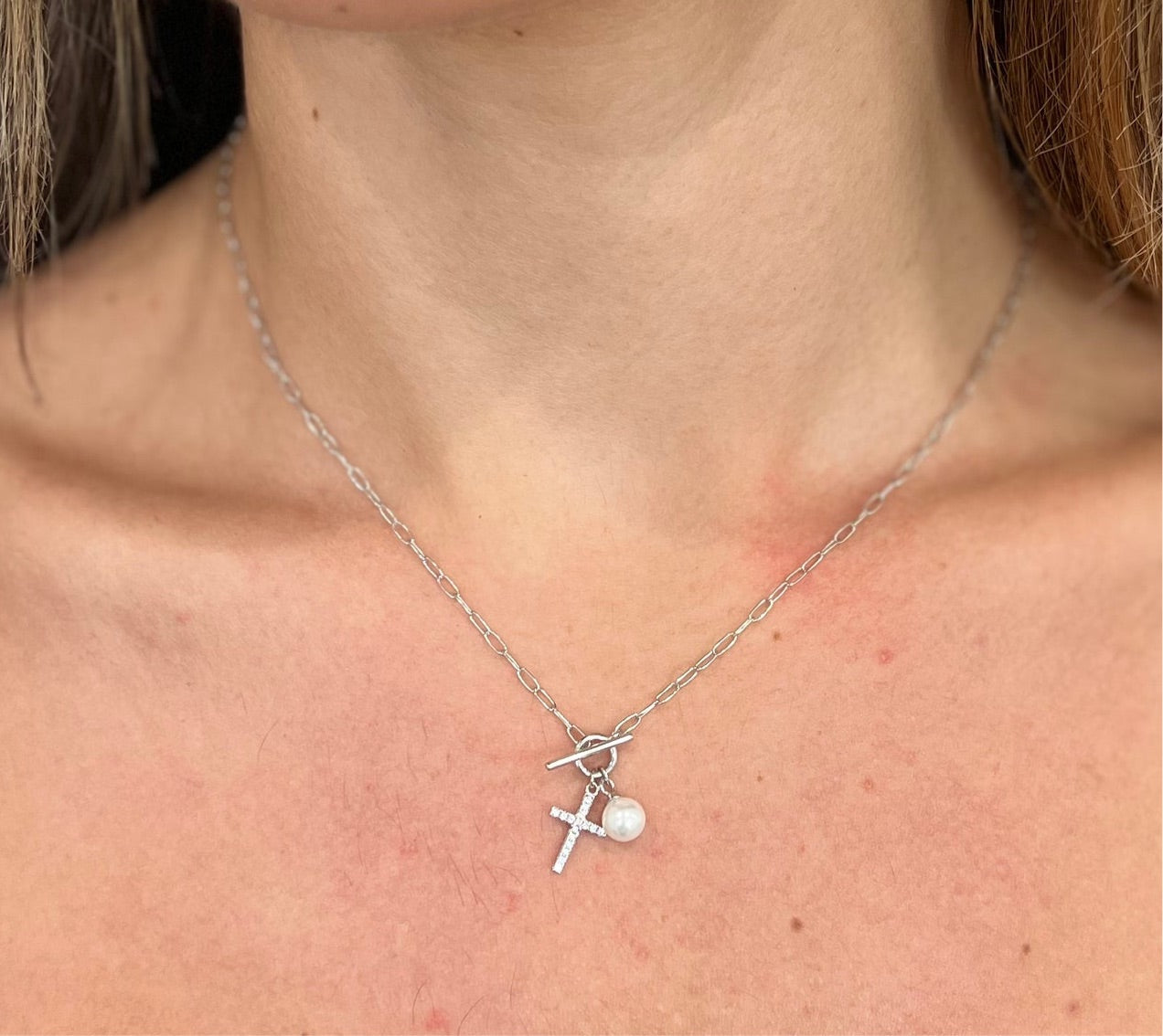 A delicate 17.5-inch Hope Necklace featuring a stylish cross design, plated in 18K gold, showcasing its dainty and meaningful appearance.