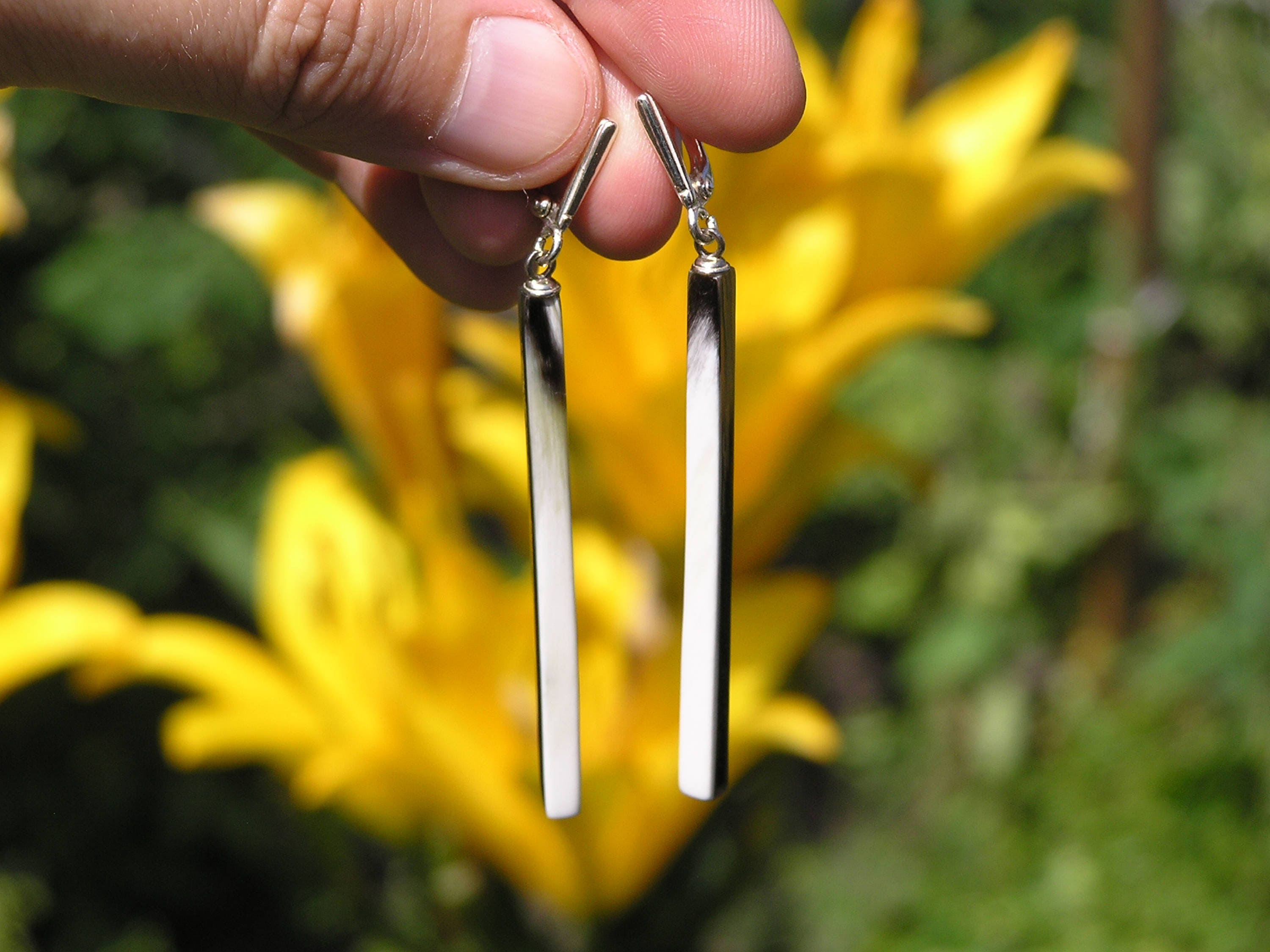 Handmade buffalo horn earrings featuring a unique geometric column design with a polished surface and silver English locks.