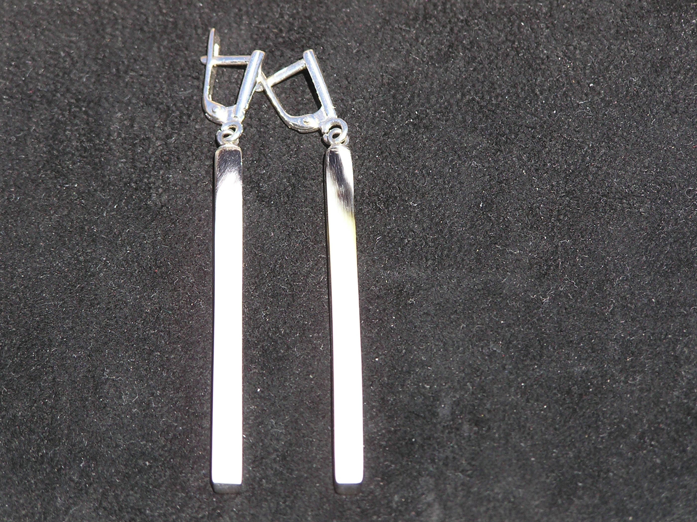 Handmade buffalo horn earrings featuring a unique geometric column design with a polished surface and silver English locks.