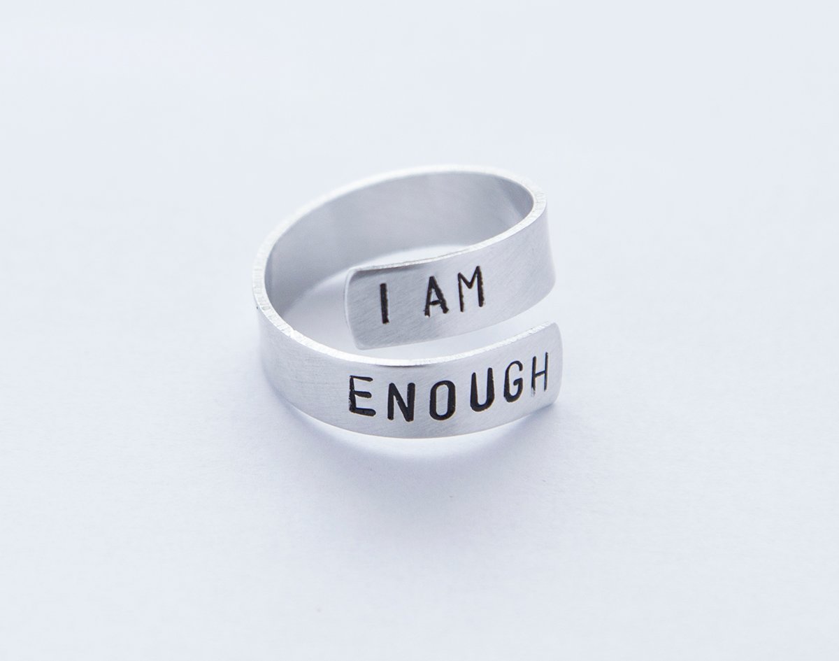 I Am Enough Ring made of lightweight aluminum, featuring hand-stamped letters, adjustable size, and a feminist message.