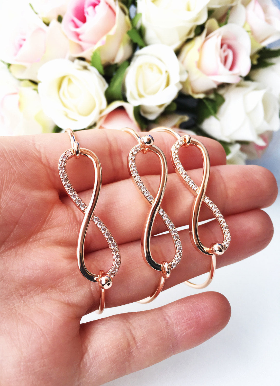Rose gold infinity bangle bracelet with zirconia stones, showcasing an elegant design perfect for any occasion.