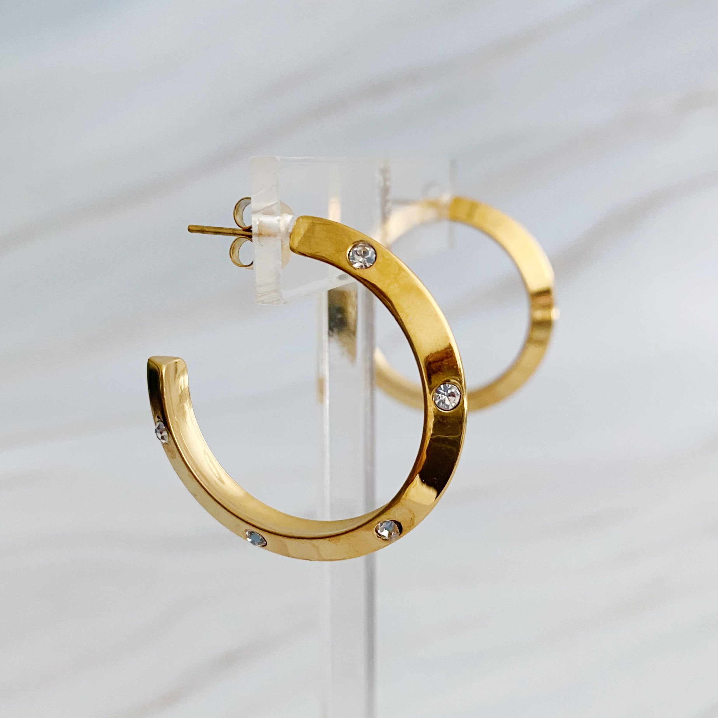 Elegant Jewel Studded Dimensional Hoop Earrings with sparkling jewels and 18K gold plating, showcasing a chic design.