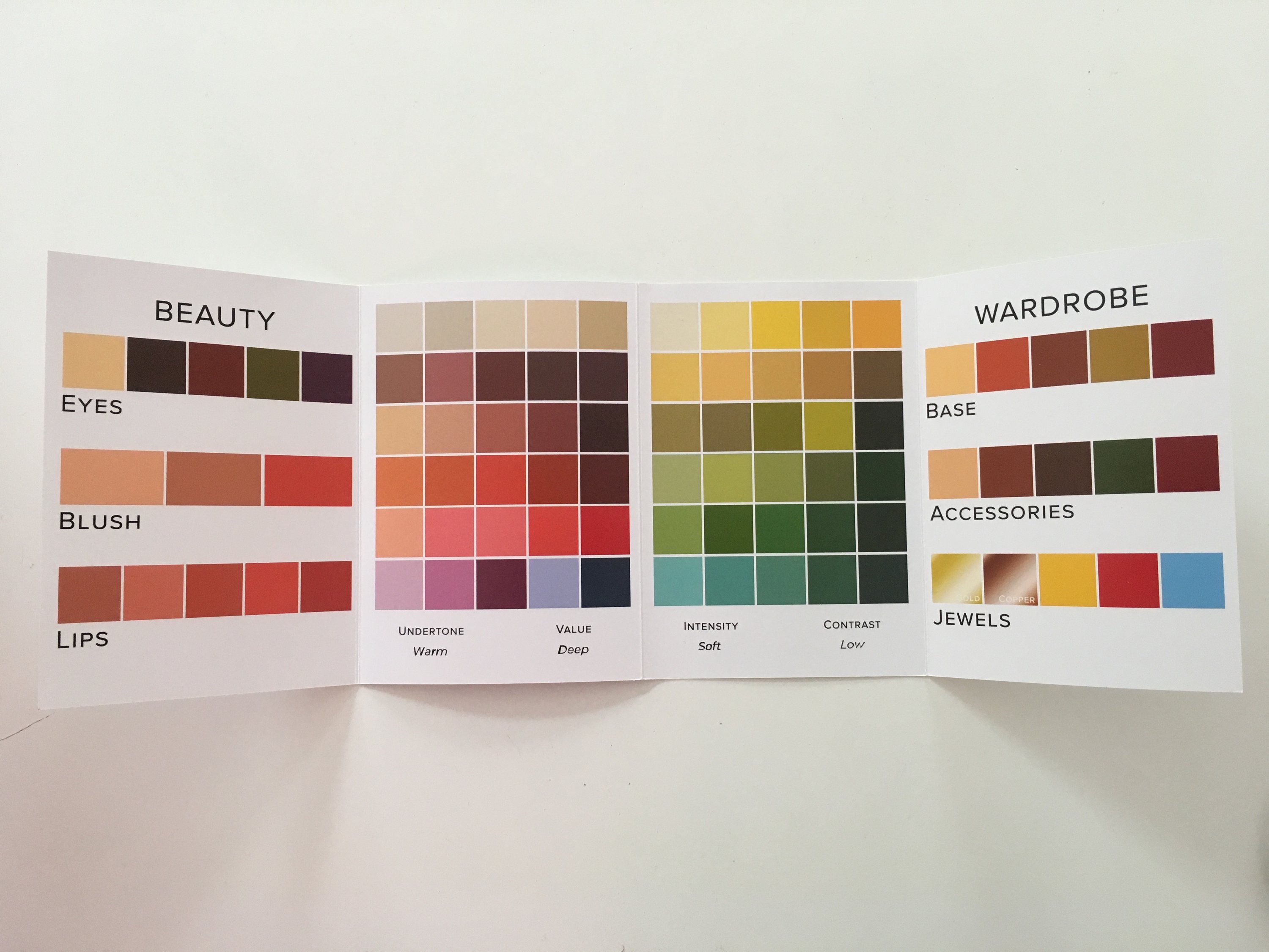 A woman participating in an online jewelry styling session, showcasing various jewelry pieces and accessories, with a laptop in front of her.