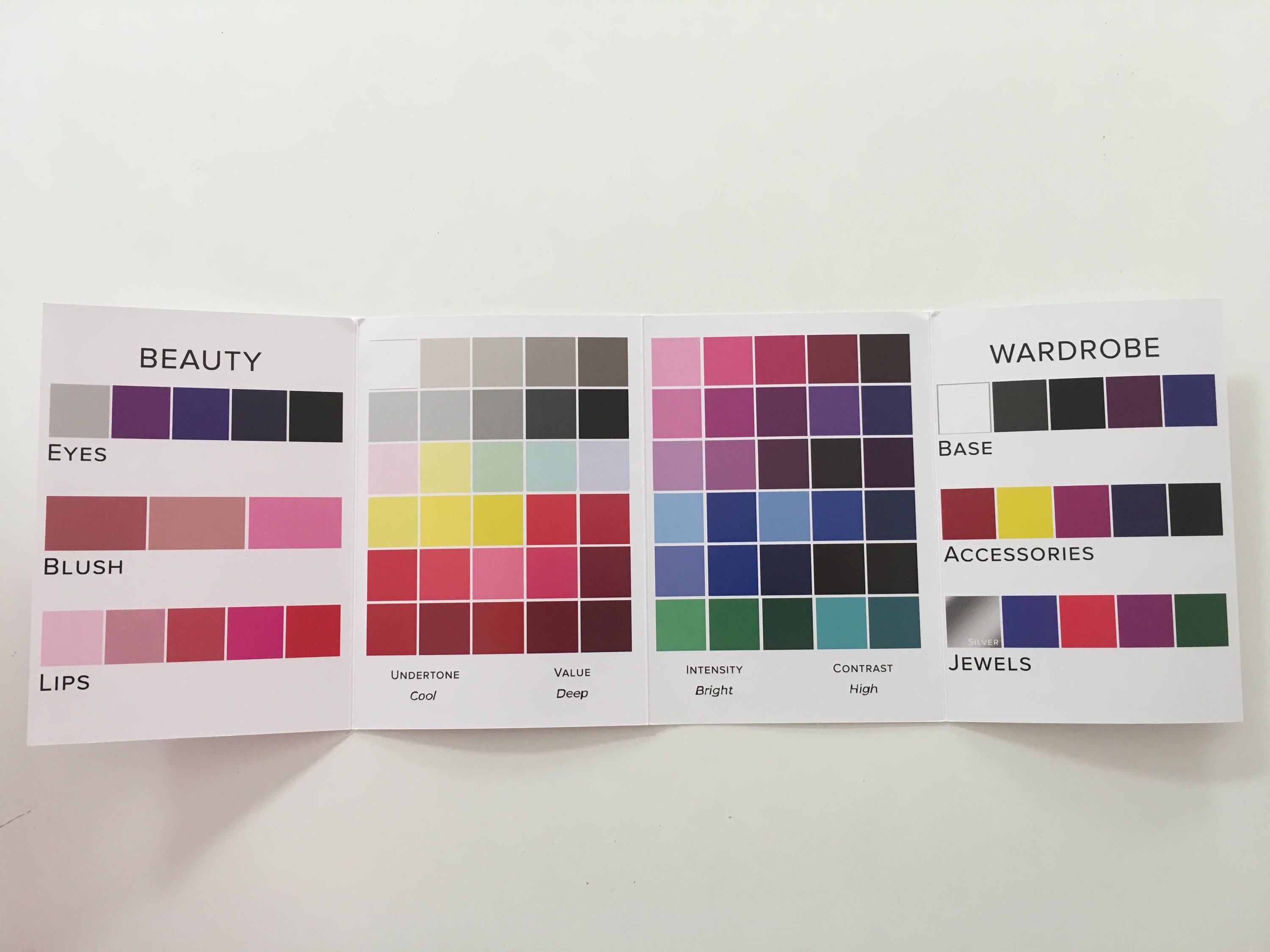 A woman participating in an online jewelry styling session, showcasing various jewelry pieces and accessories, with a laptop in front of her.