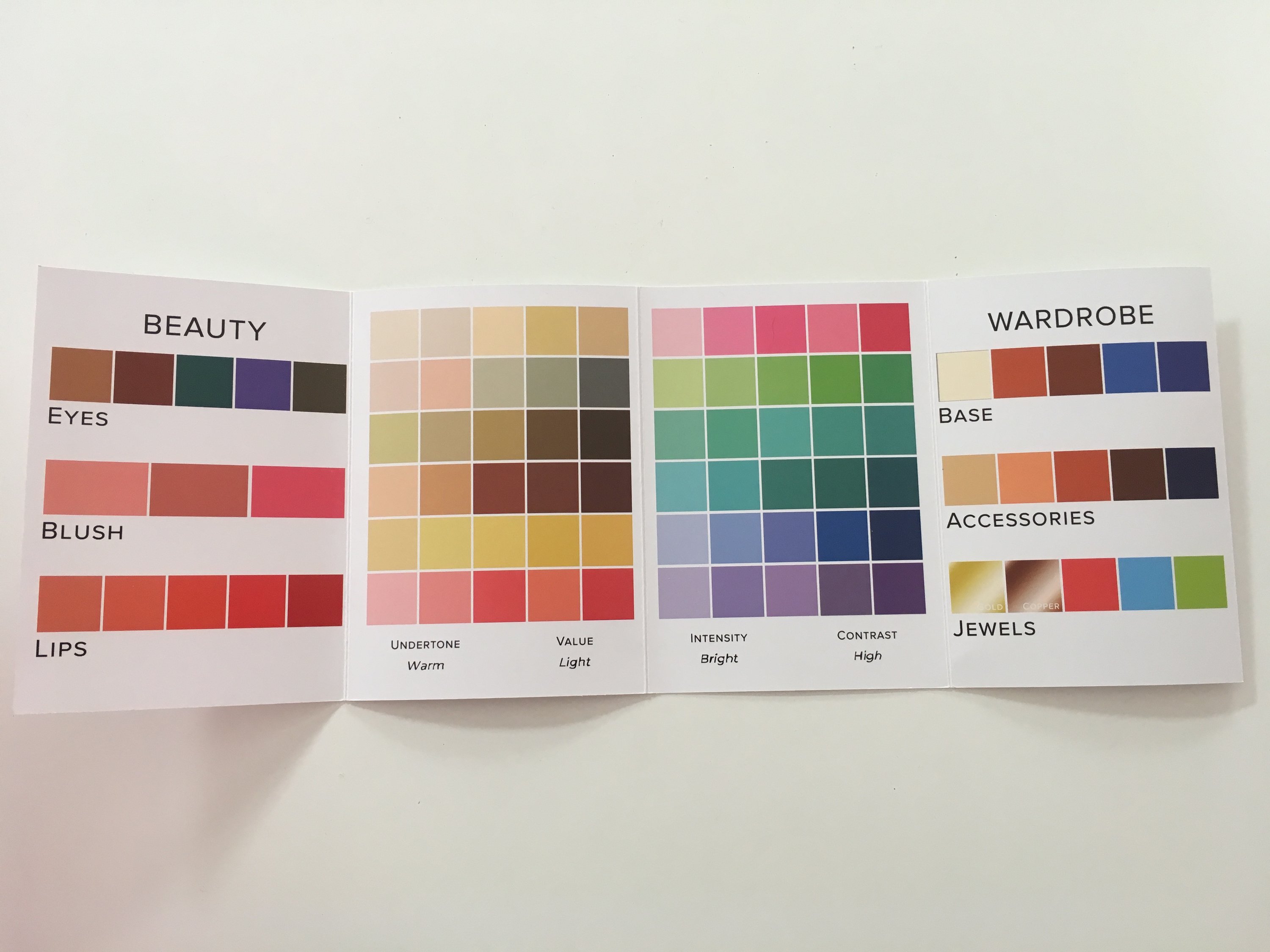 A woman participating in an online jewelry styling session, showcasing various jewelry pieces and accessories, with a laptop in front of her.