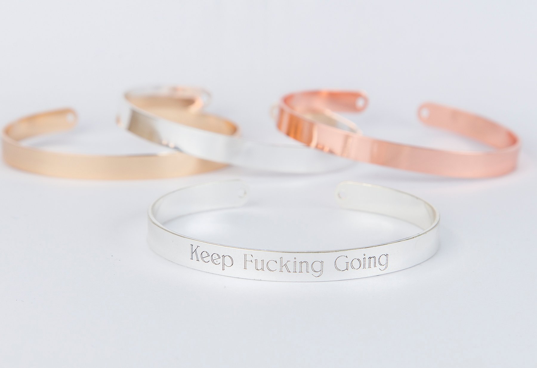 Keep Fucking Going Bracelet in gold, rose gold, and silver plating, adjustable design with motivational engraving.