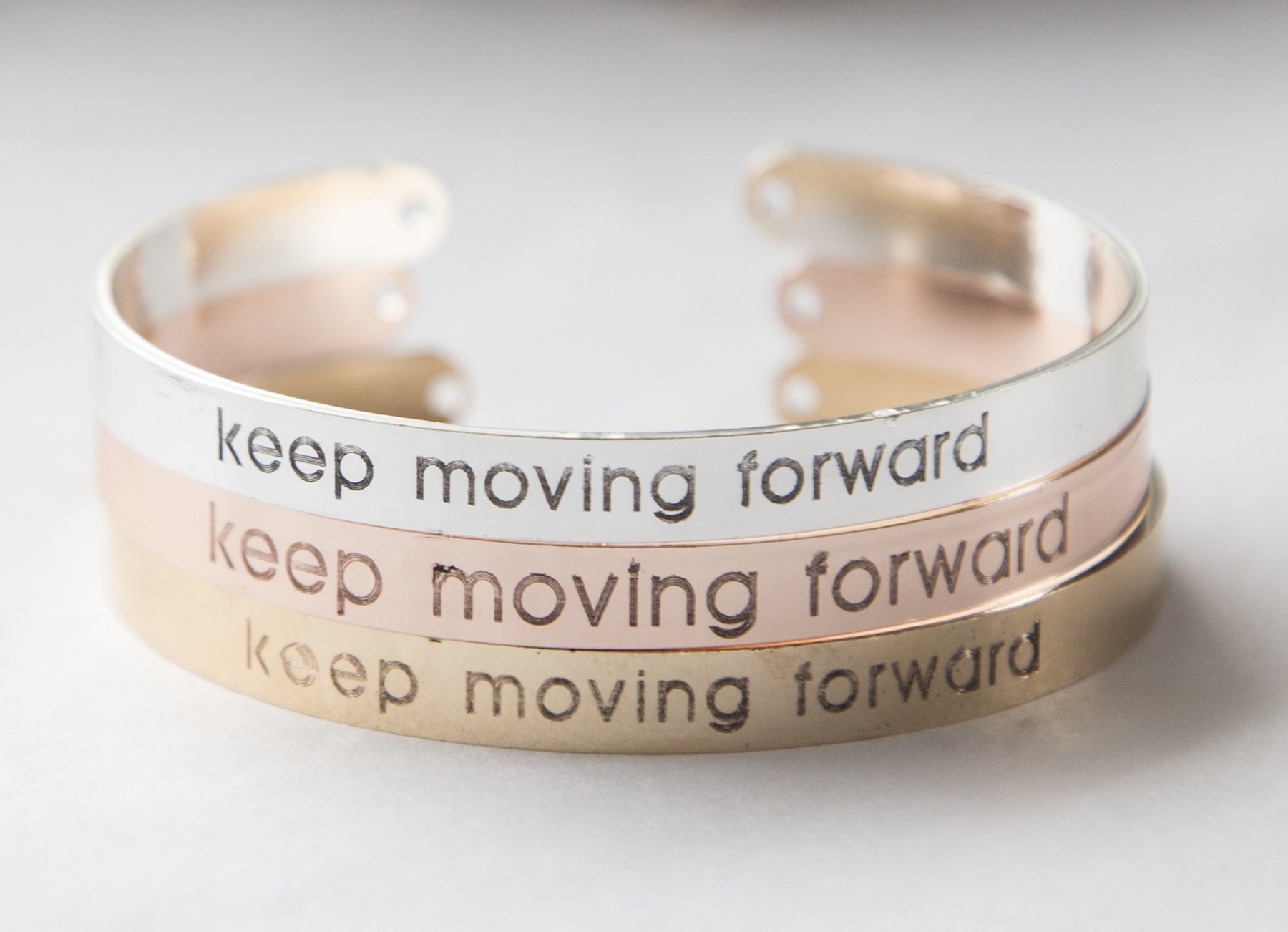 Keep Moving Forward Bracelet in gold plating, featuring an inspirational message and adjustable design for comfort.