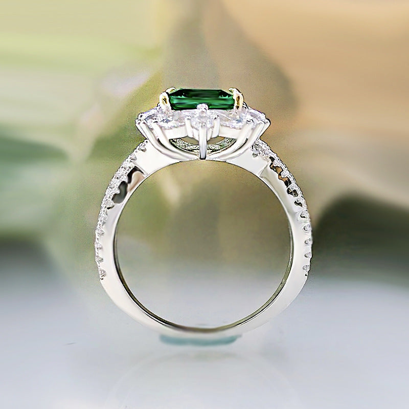 A stunning lab emerald baguette sterling silver ring featuring a vibrant green center stone surrounded by sparkling white sapphires.