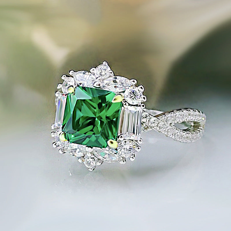 A stunning lab emerald baguette sterling silver ring featuring a vibrant green center stone surrounded by sparkling white sapphires.