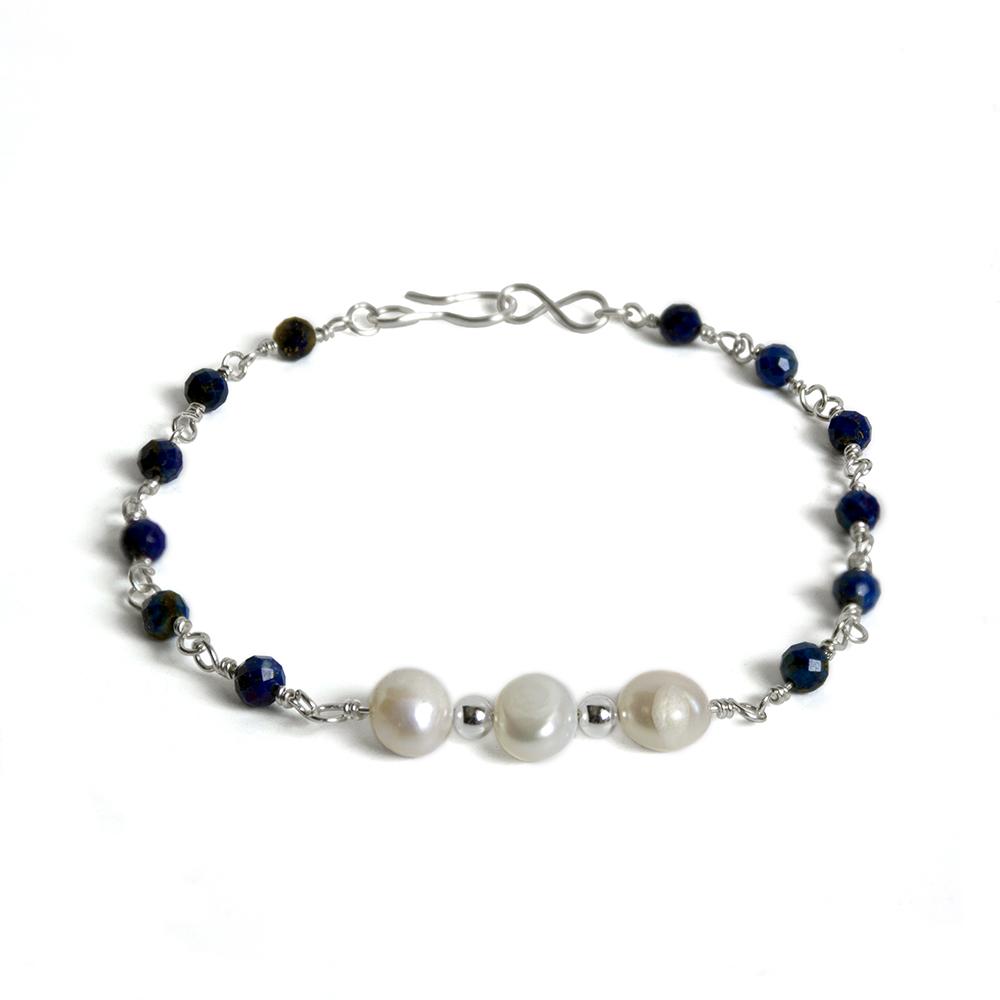 A beautiful Lapis Lazuli and Freshwater Pearl Sterling Silver Chain Bracelet featuring rich blue lapis lazuli stones and elegant baroque freshwater pearls.
