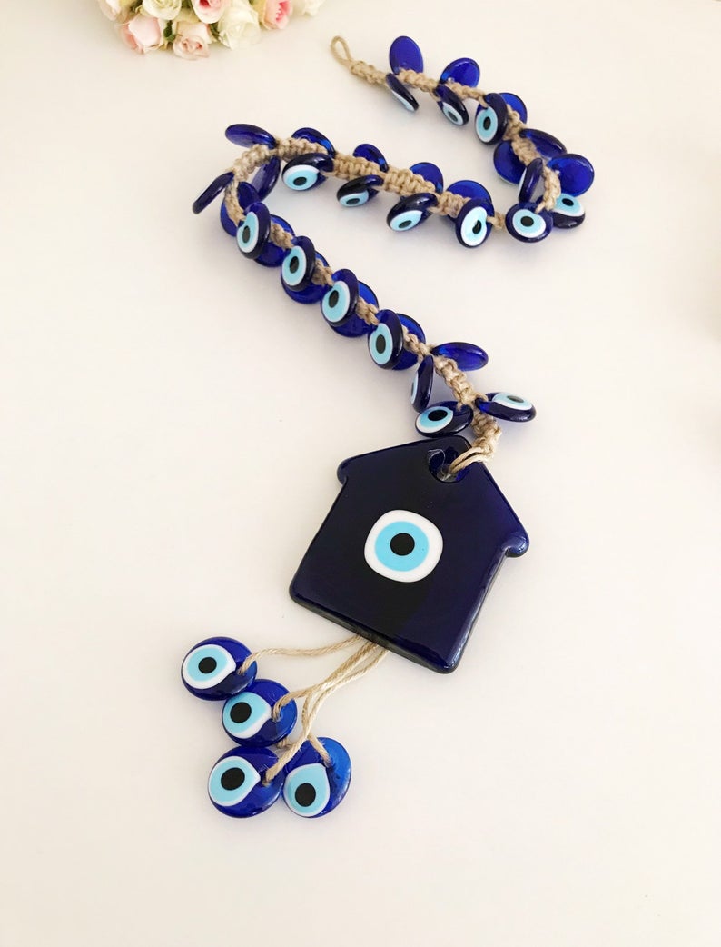 Large evil eye wall hanging with 41 beads, featuring a big evil eye bead and 40 smaller beads, handmade and unique.