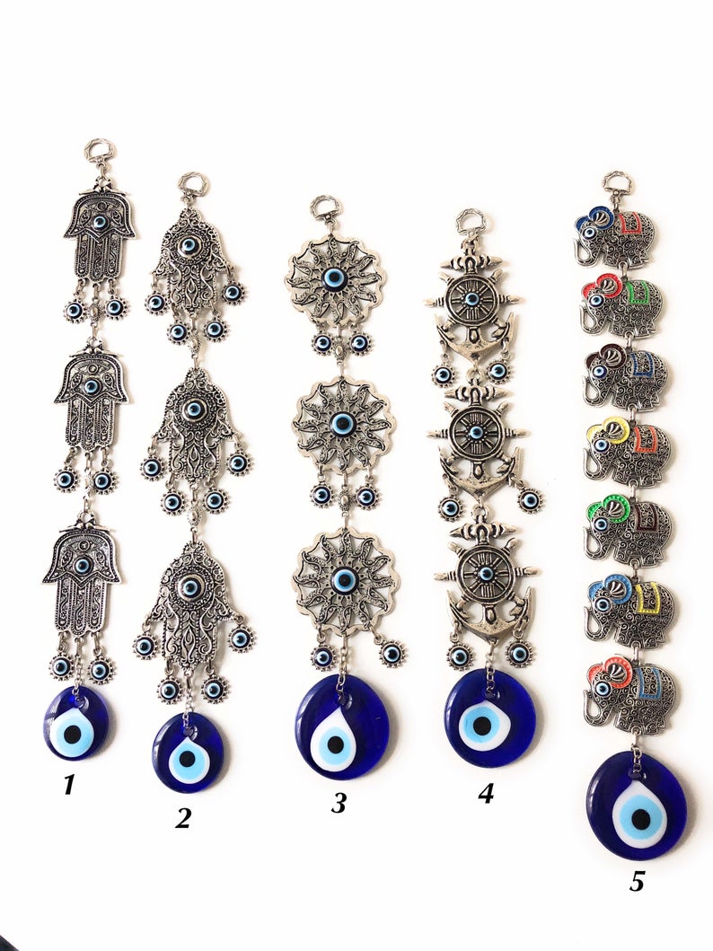Large Evil Eye Wall Hanging featuring blue evil eye bead, hamsa hand, and lucky elephant designs, crafted from metal for home decor.