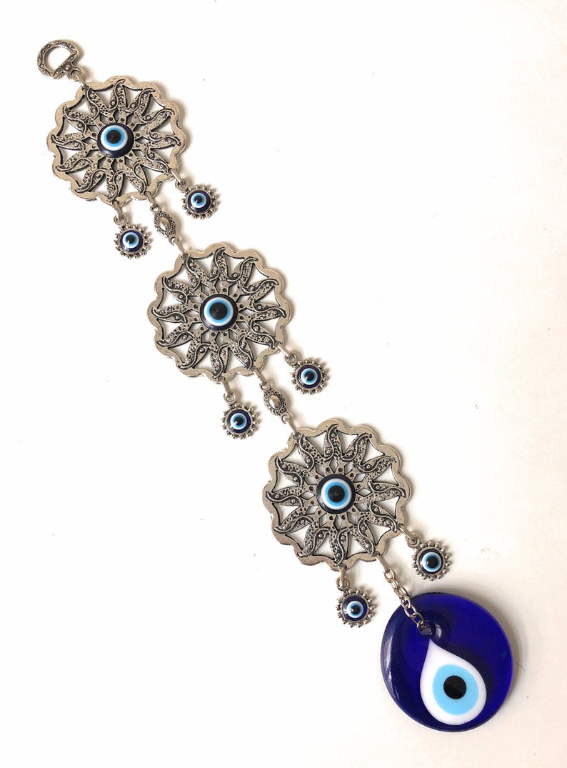 Large Evil Eye Wall Hanging featuring blue evil eye bead, hamsa hand, and lucky elephant designs, crafted from metal for home decor.