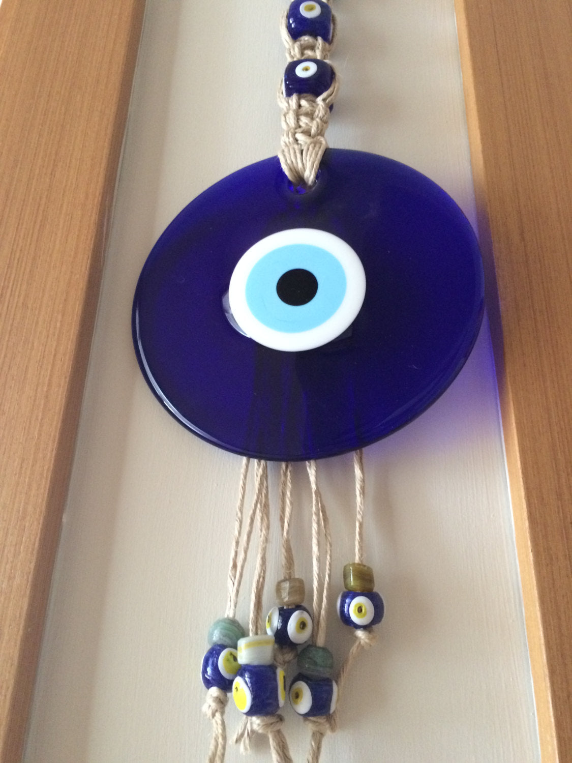 Large Macrame Evil Eye Wall Hanging featuring a central 18cm evil eye surrounded by smaller glass evil eyes, intricately designed with macrame.