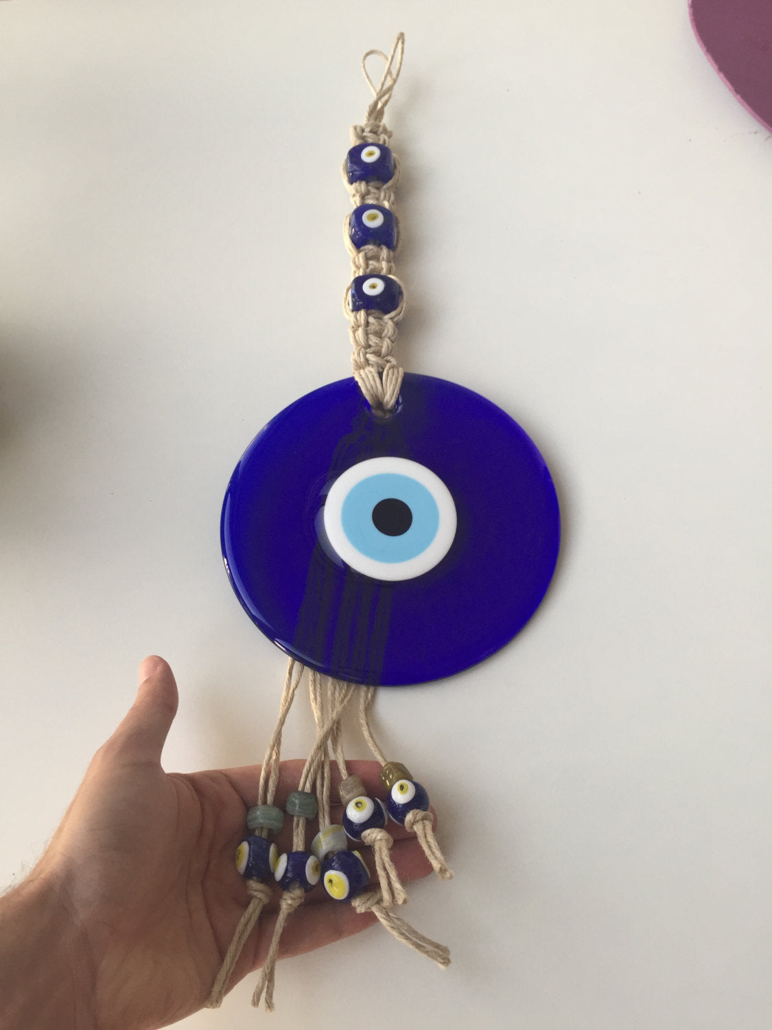 Large Macrame Evil Eye Wall Hanging featuring a central 18cm evil eye surrounded by smaller glass evil eyes, intricately designed with macrame.