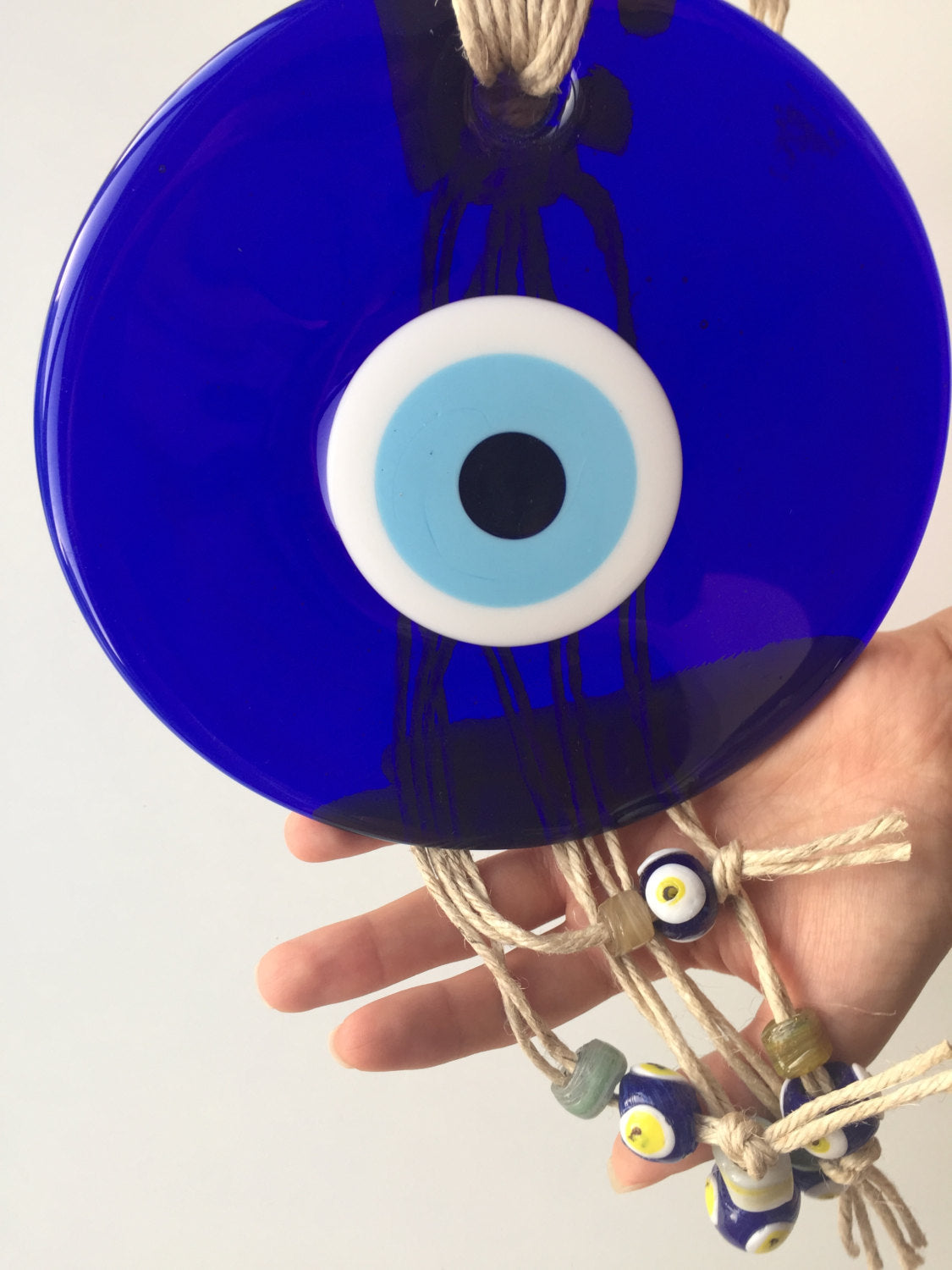 Large Macrame Evil Eye Wall Hanging featuring a central 18cm evil eye surrounded by smaller glass evil eyes, intricately designed with macrame.