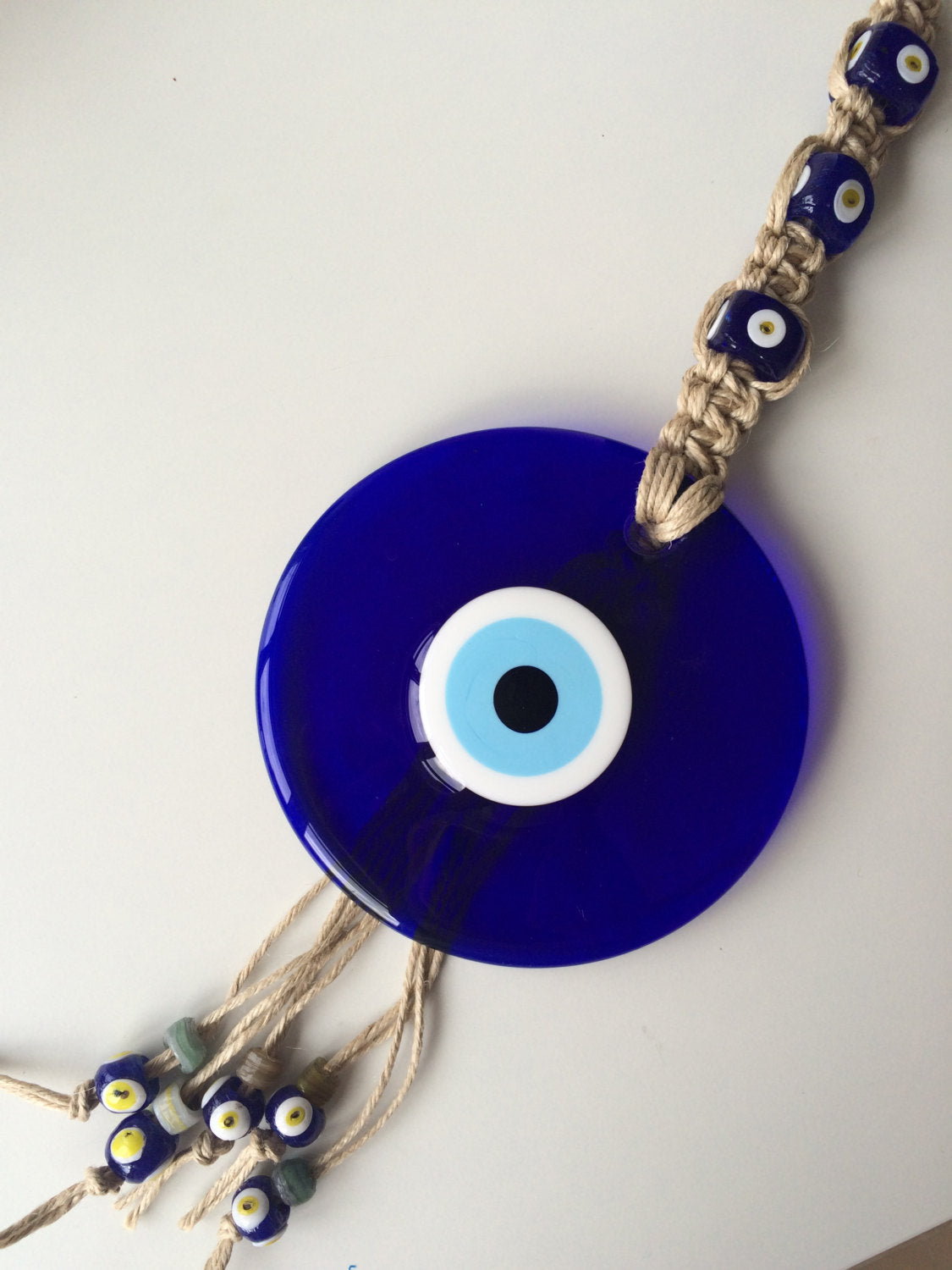 Large Macrame Evil Eye Wall Hanging featuring a central 18cm evil eye surrounded by smaller glass evil eyes, intricately designed with macrame.