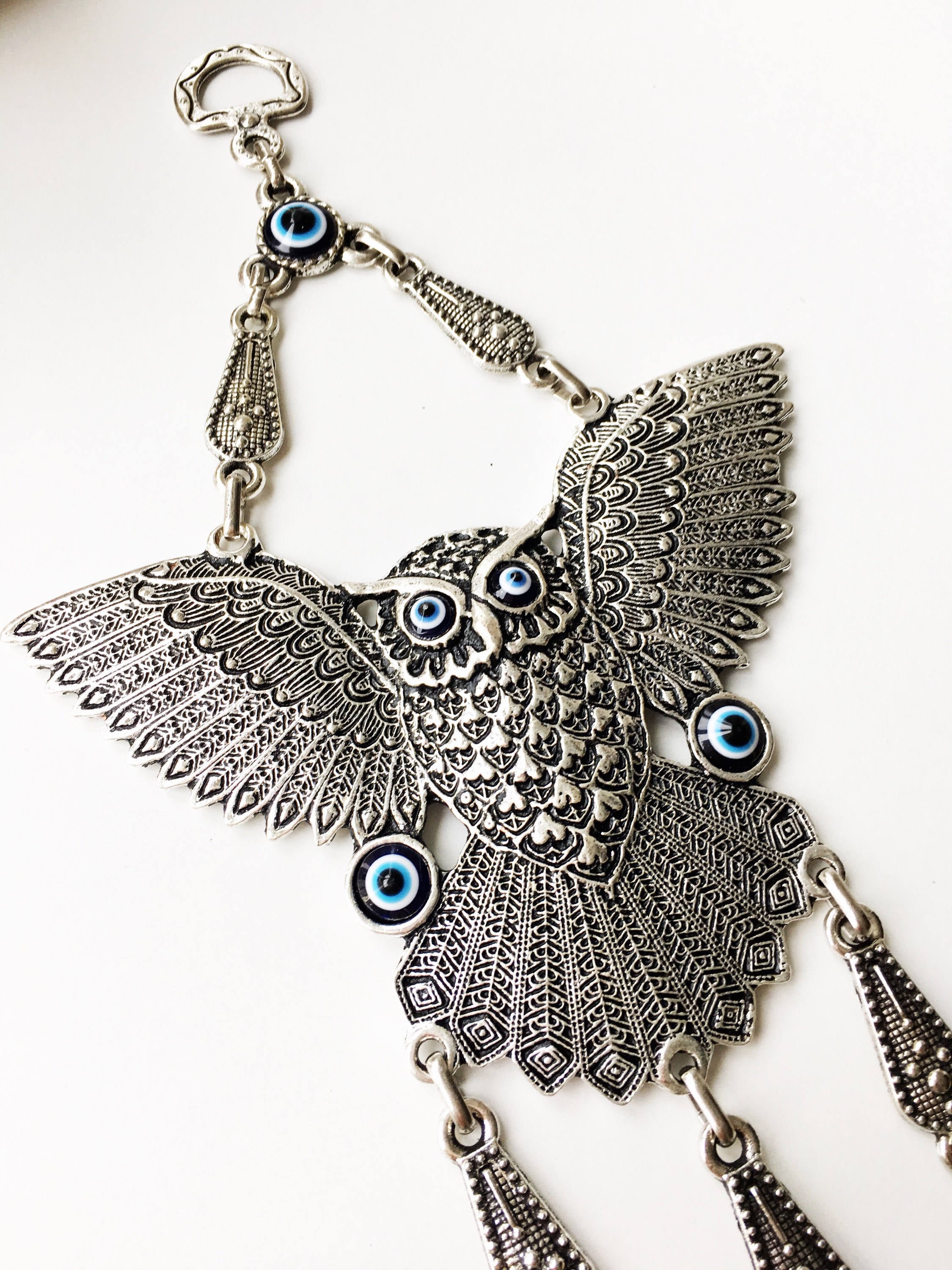 A beautifully handcrafted Large Owl Evil Eye Wall Hanging featuring a vibrant glass evil eye bead and intricate metal charm details.