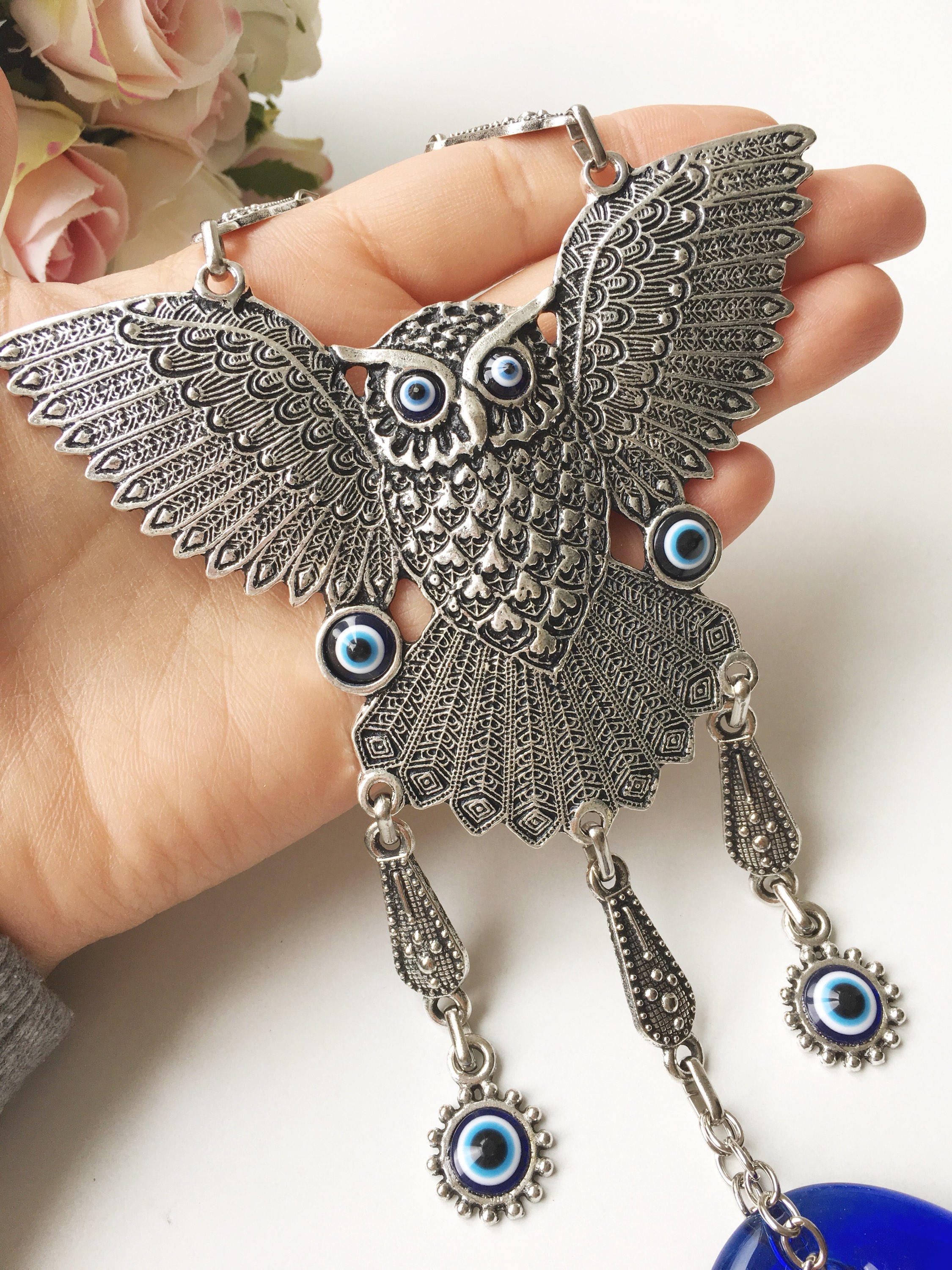 A beautifully handcrafted Large Owl Evil Eye Wall Hanging featuring a vibrant glass evil eye bead and intricate metal charm details.