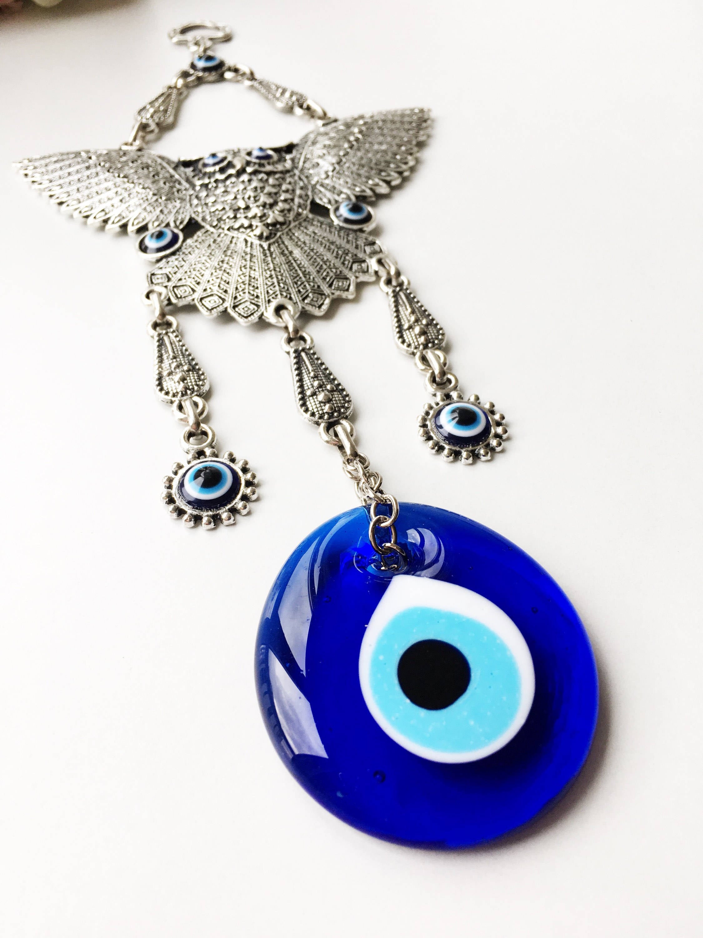 A beautifully handcrafted Large Owl Evil Eye Wall Hanging featuring a vibrant glass evil eye bead and intricate metal charm details.