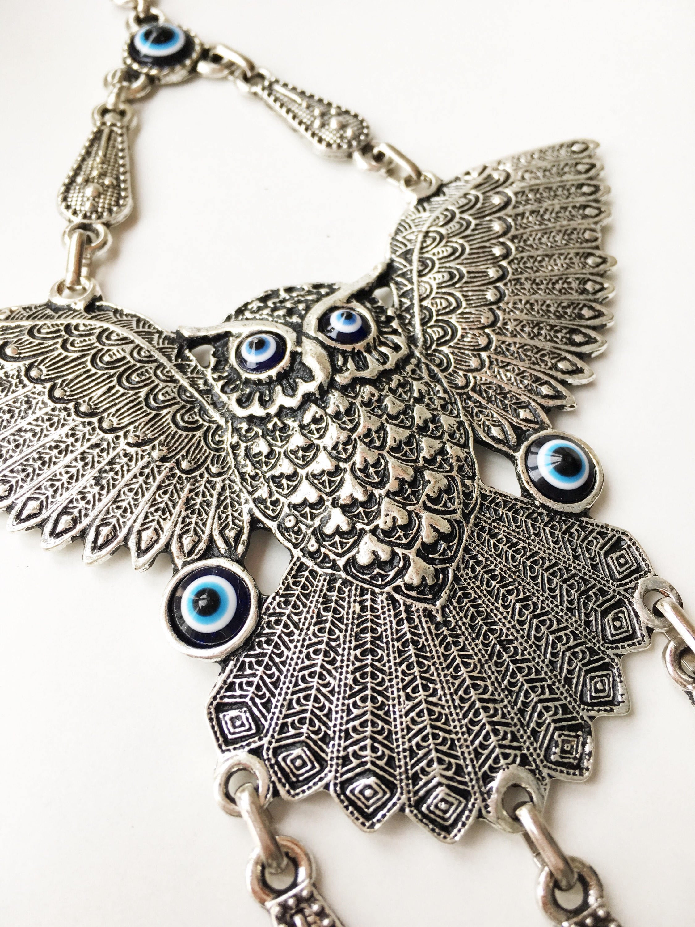 A beautifully handcrafted Large Owl Evil Eye Wall Hanging featuring a vibrant glass evil eye bead and intricate metal charm details.