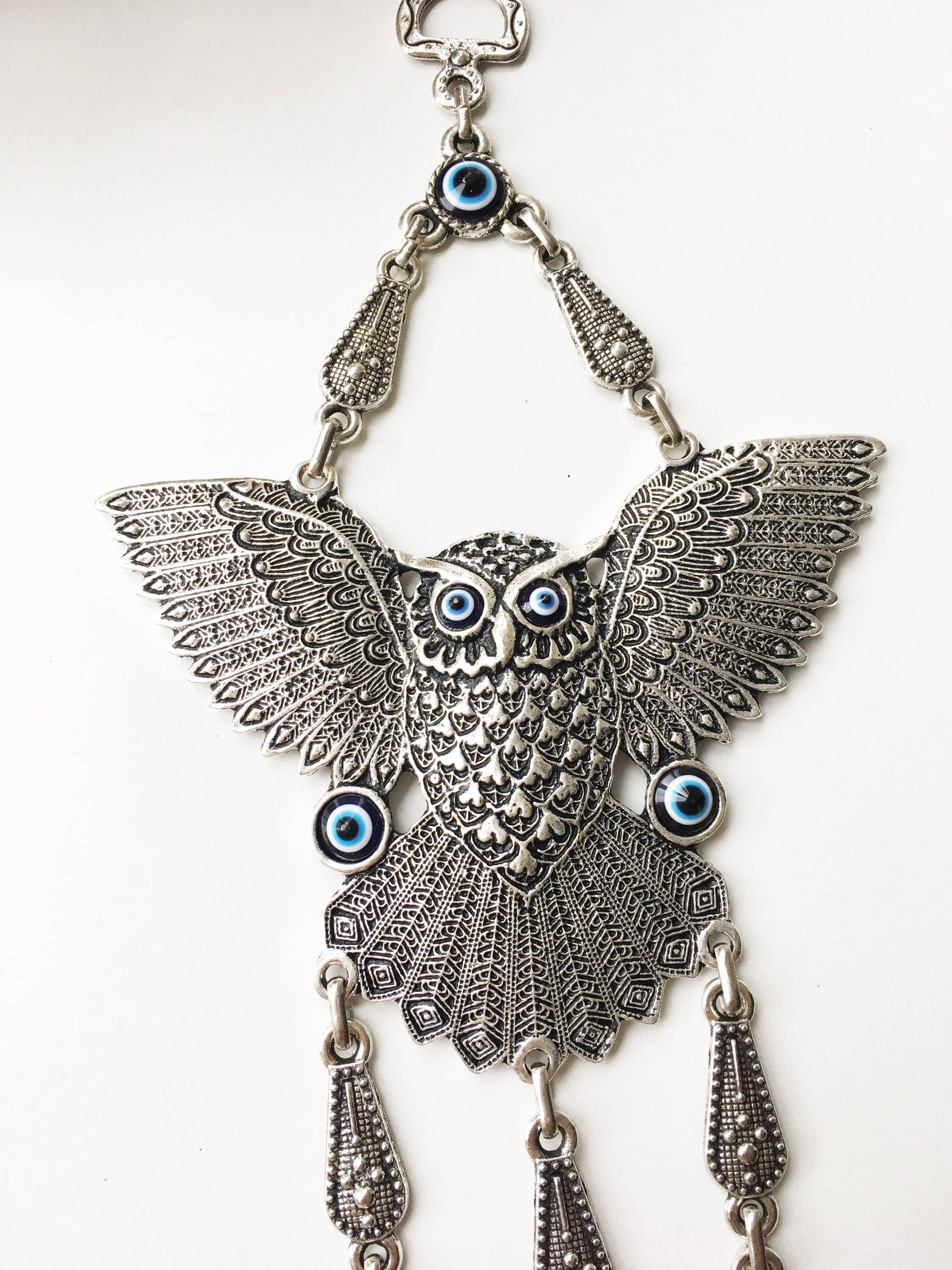 A beautifully handcrafted Large Owl Evil Eye Wall Hanging featuring a vibrant glass evil eye bead and intricate metal charm details.