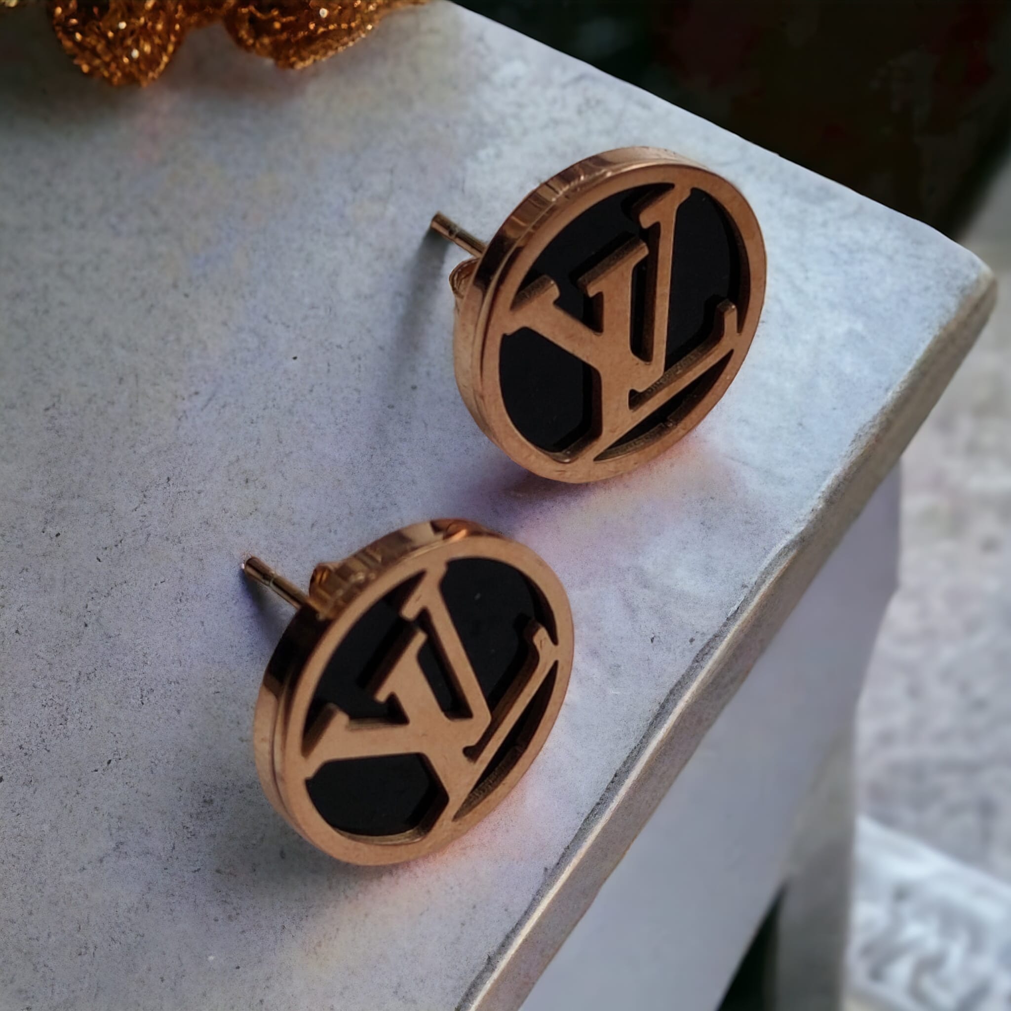 Large round black elegant rose gold plated stud earrings showcasing a contemporary design with a luxurious finish.