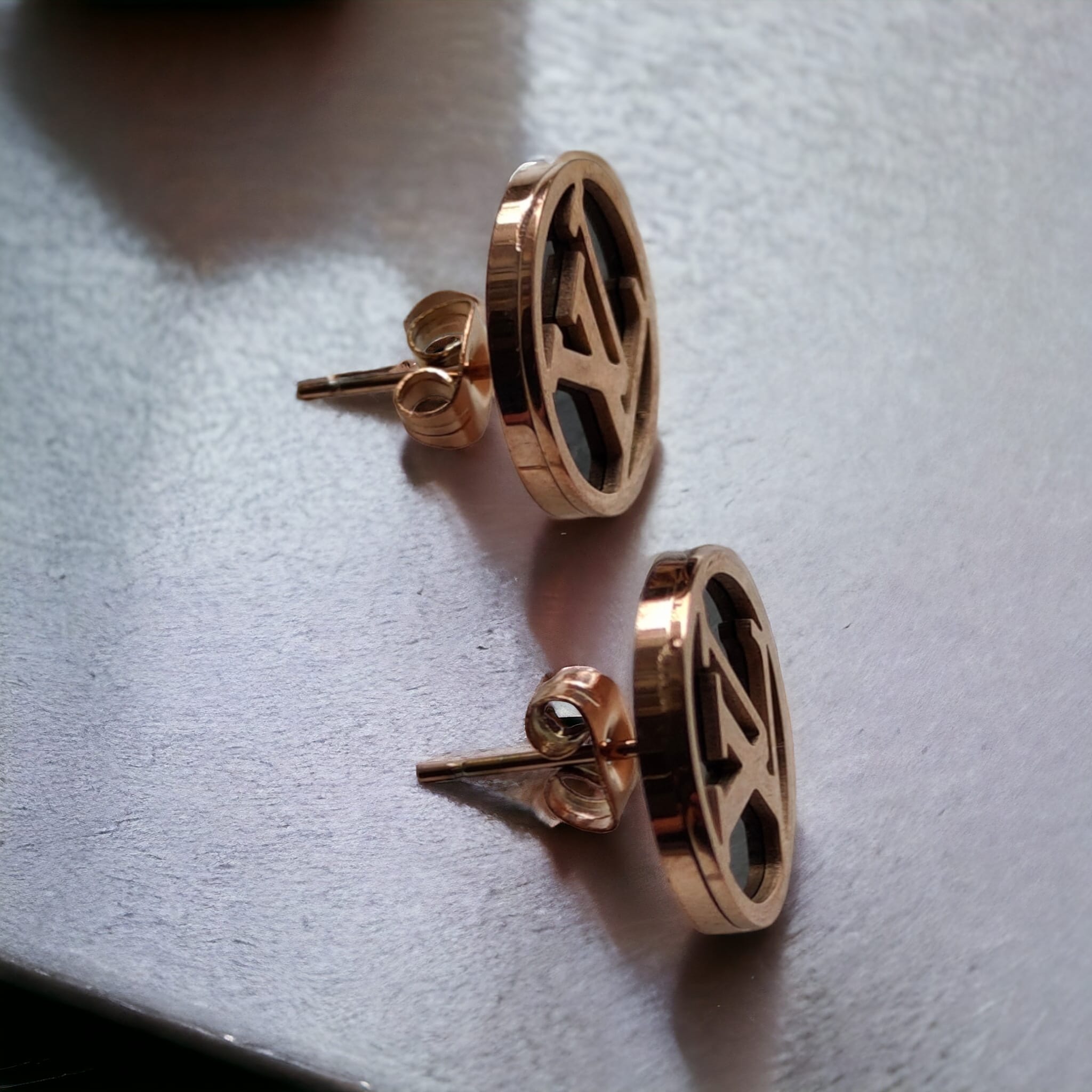 Large round black elegant rose gold plated stud earrings showcasing a contemporary design with a luxurious finish.