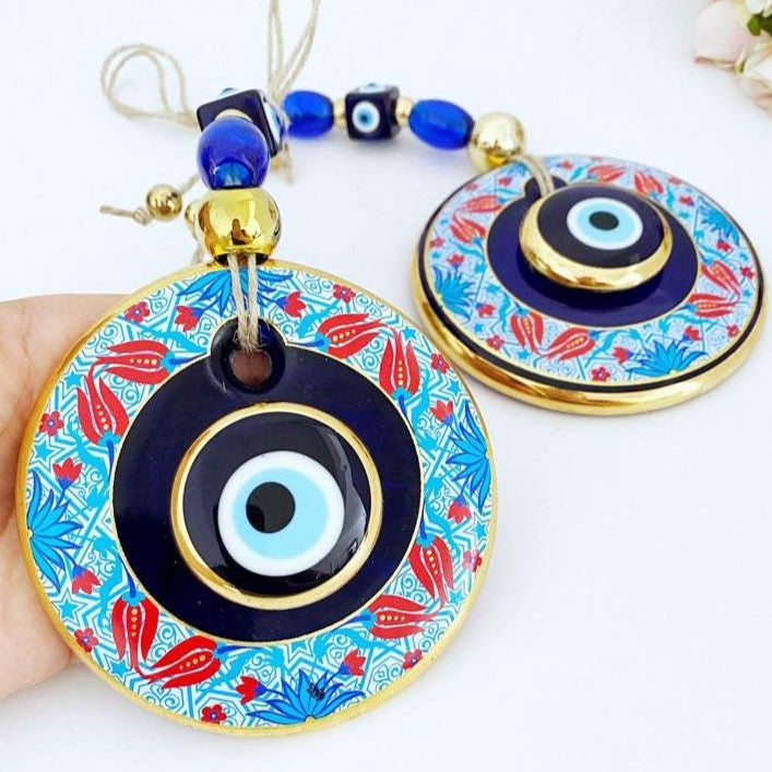 A beautifully handpainted Larger Evil Eye Wall Hanging featuring a large glass round evil eye and smaller evil eyes, perfect for home decor.
