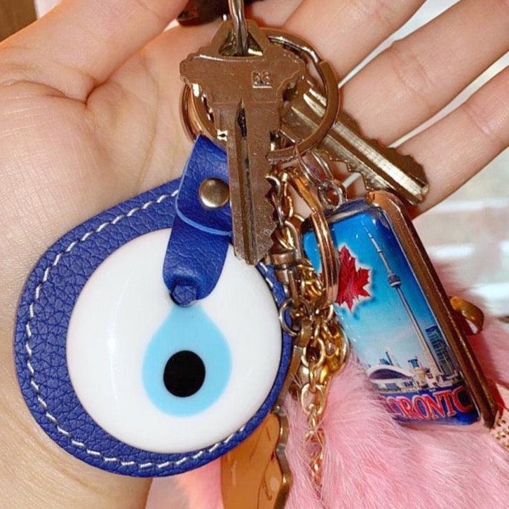 Leather Evil Eye Keychain featuring a blue glass evil eye, stylish leather design, and available in multiple colors.