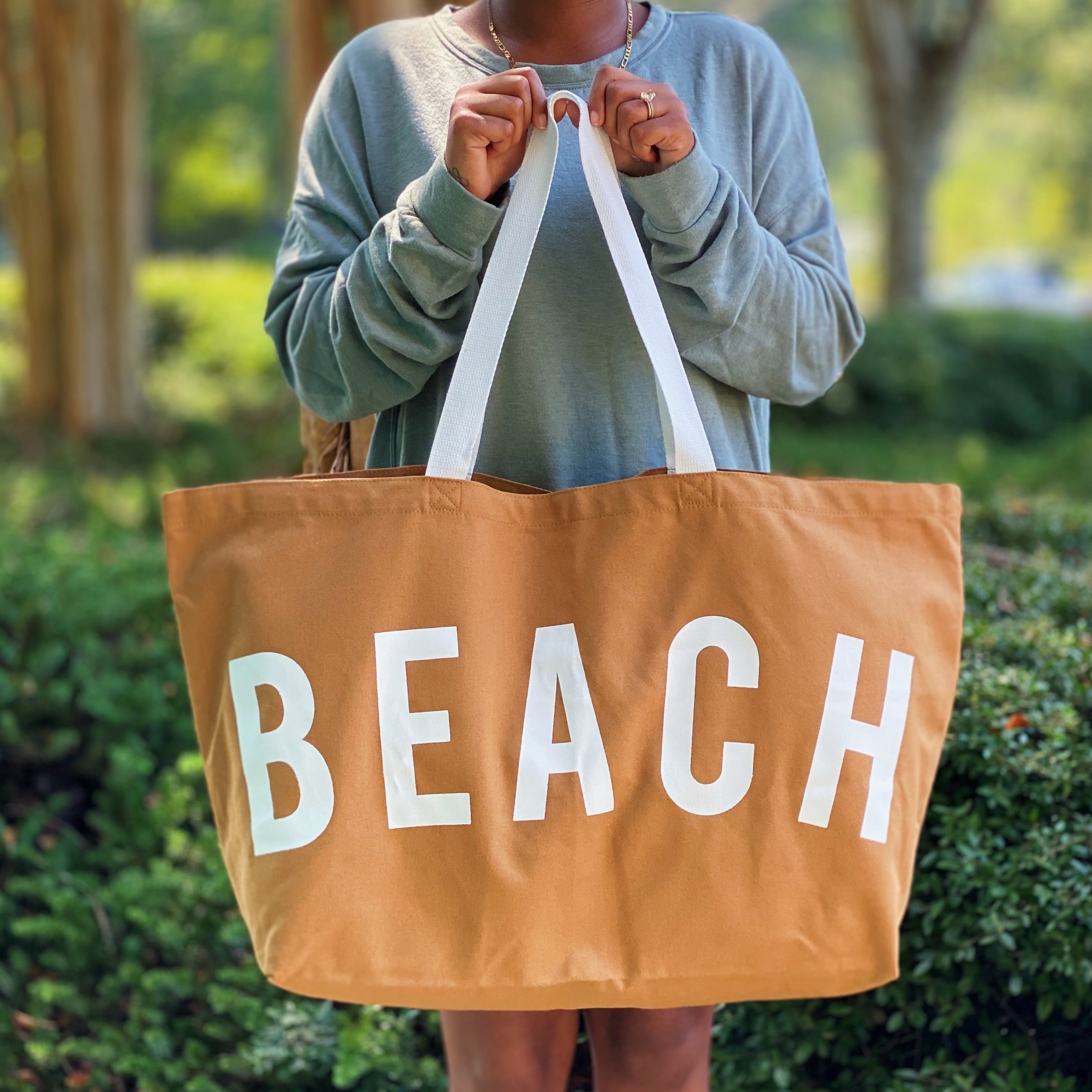 A spacious Let’s Do Beach Canvas Tote featuring the word 'BEACH' in stylish font, perfect for carrying essentials for beach outings and more.