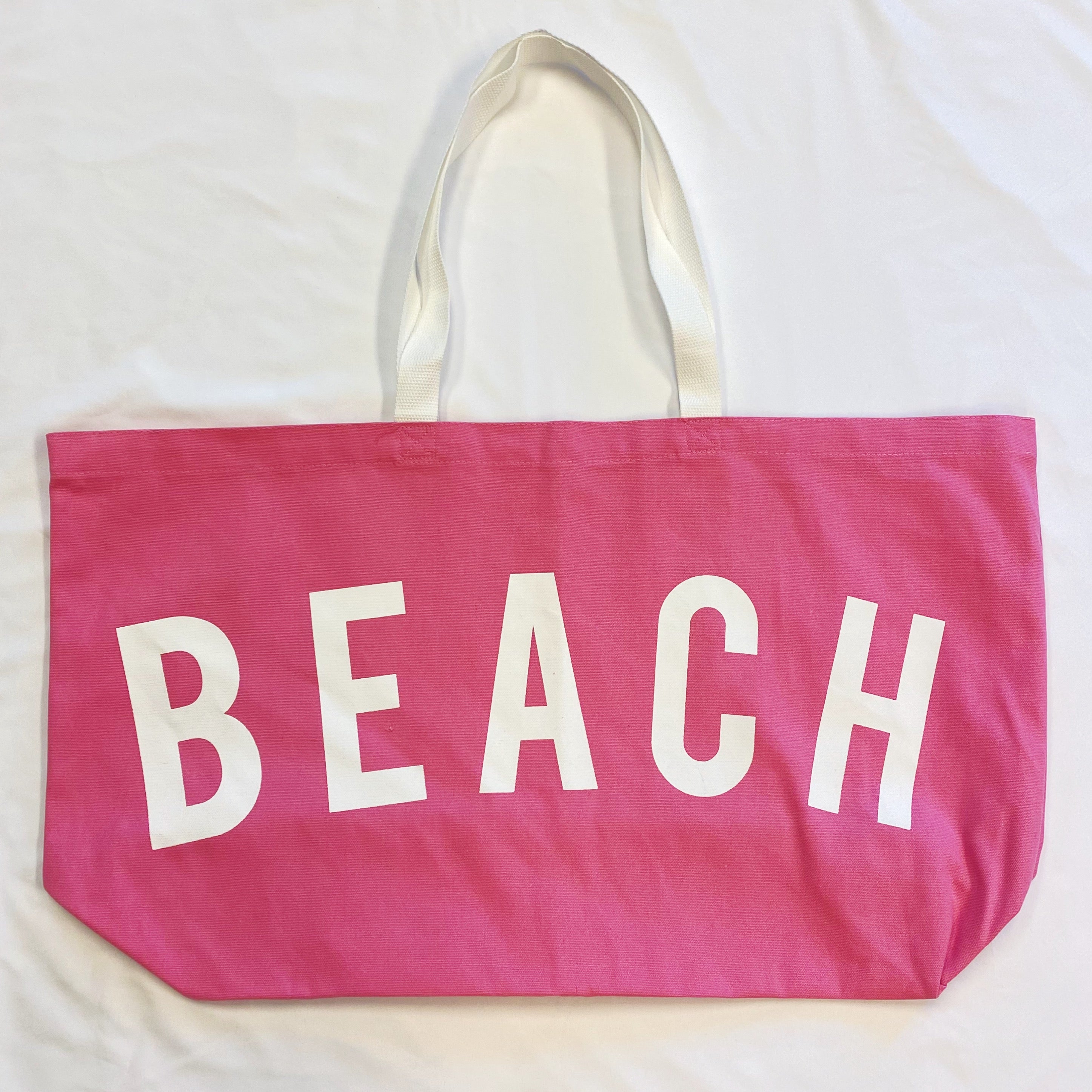 A spacious Let’s Do Beach Canvas Tote featuring the word 'BEACH' in stylish font, perfect for carrying essentials for beach outings and more.