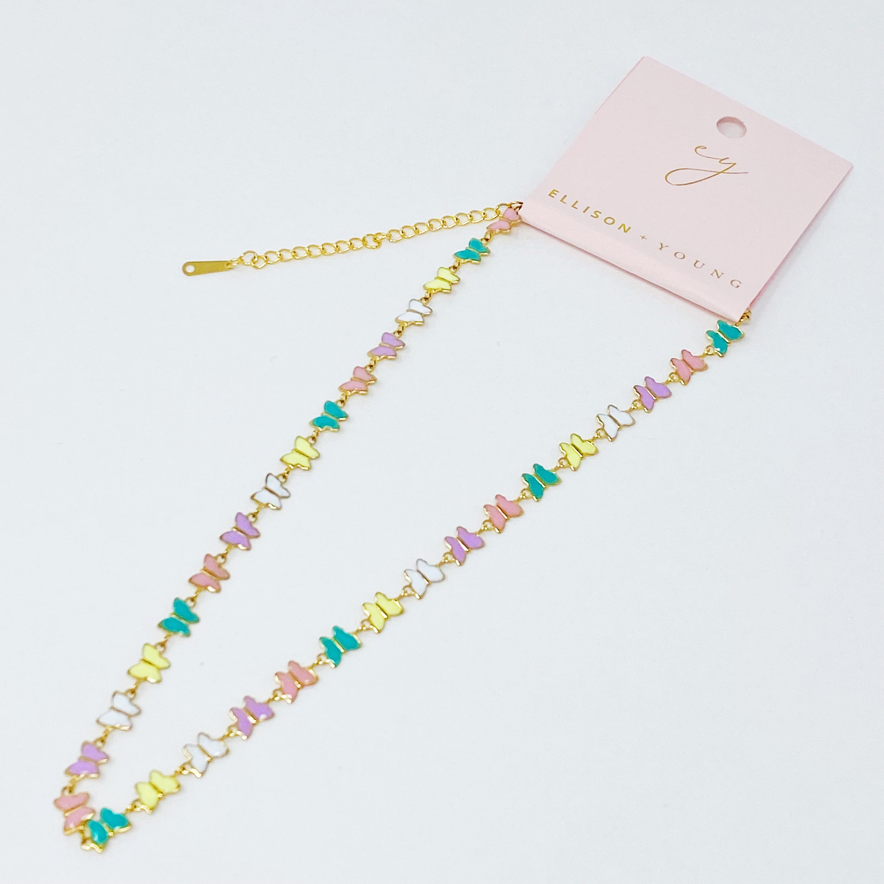 Linked Butterflies Necklace featuring pastel butterflies and a solid gold reversible side, crafted from gold plated stainless steel.