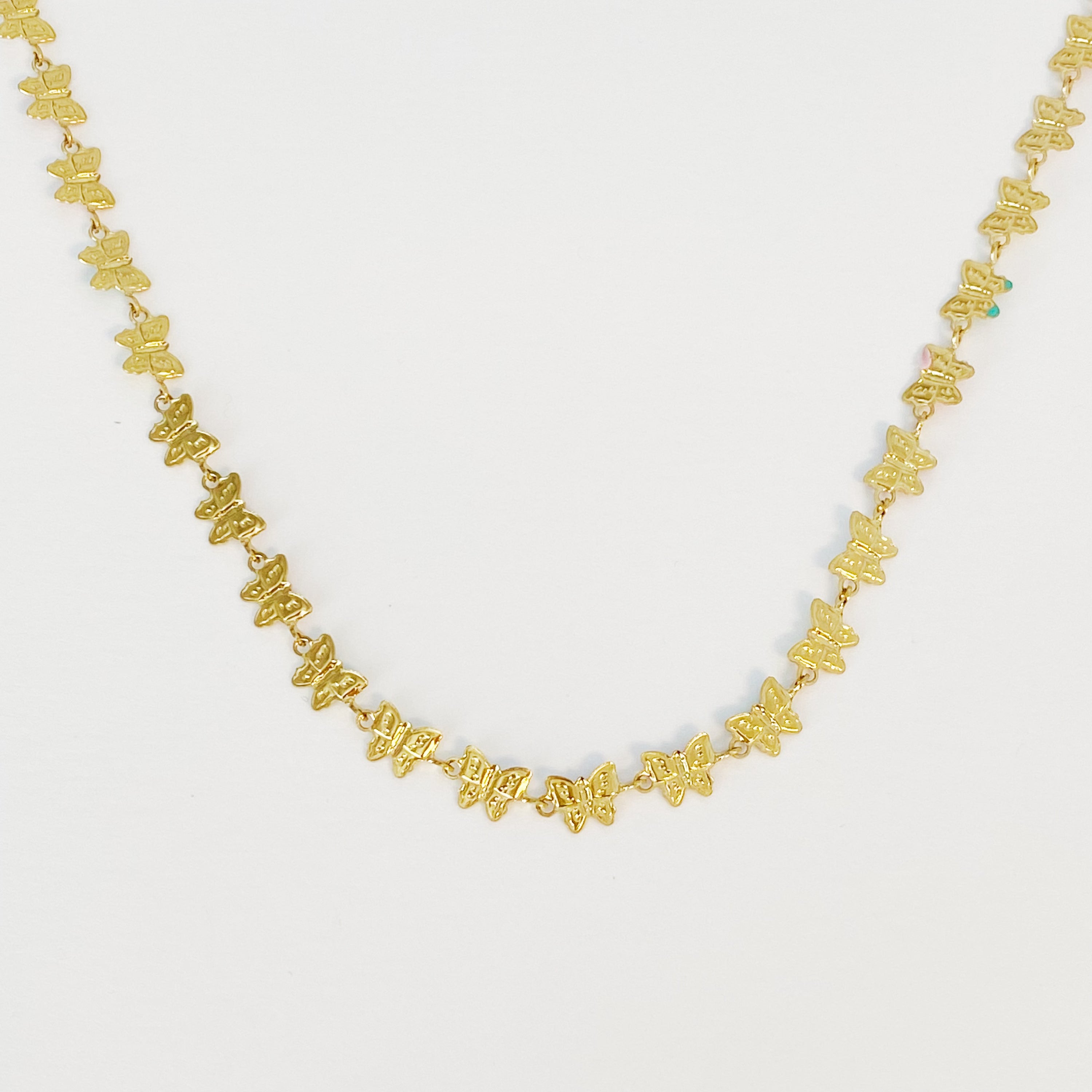 Linked Butterflies Necklace featuring pastel butterflies and a solid gold reversible side, crafted from gold plated stainless steel.