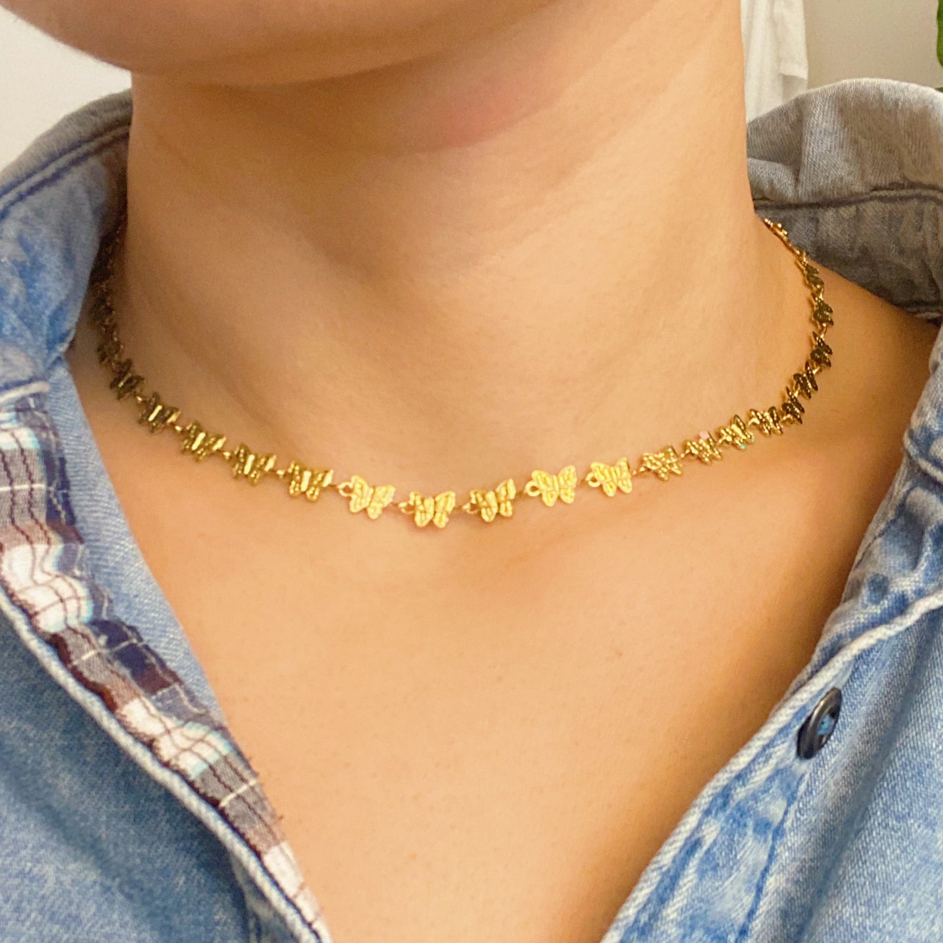 Linked Butterflies Necklace featuring pastel butterflies and a solid gold reversible side, crafted from gold plated stainless steel.