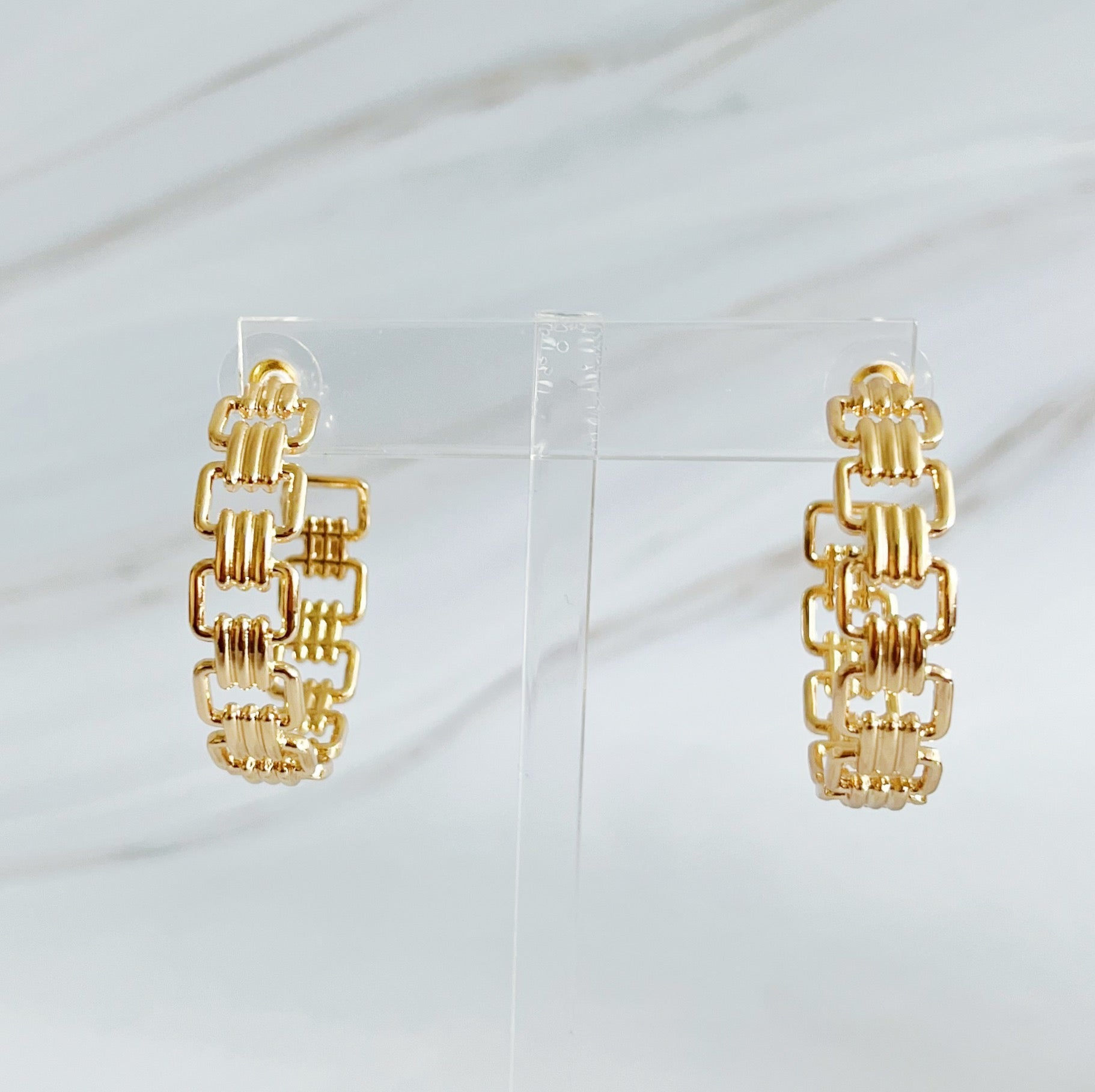 Elegant Linked Golden Hoop Earrings with a modern design, showcasing a unique linked pattern and a beautiful golden finish.