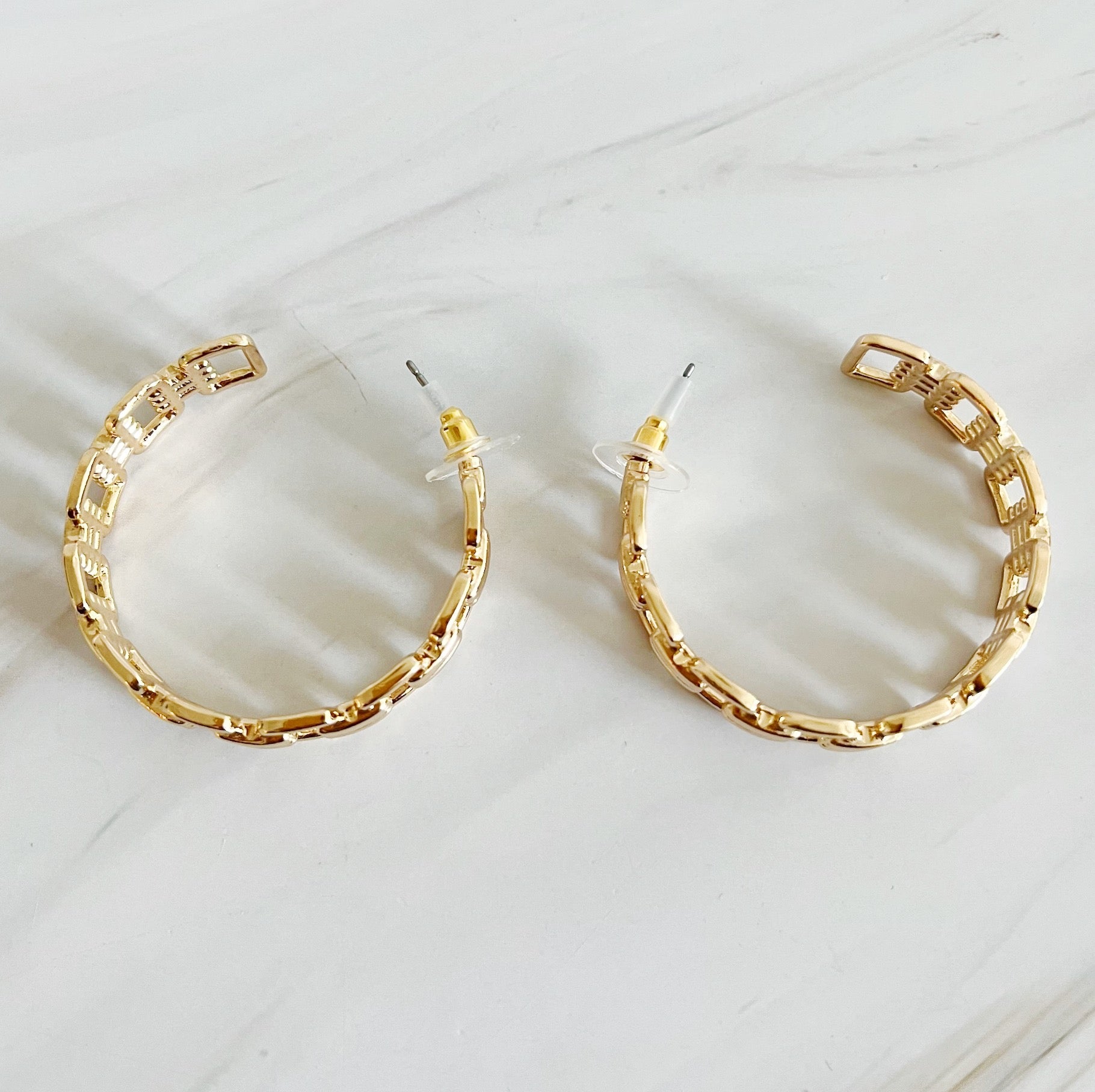 Elegant Linked Golden Hoop Earrings with a modern design, showcasing a unique linked pattern and a beautiful golden finish.