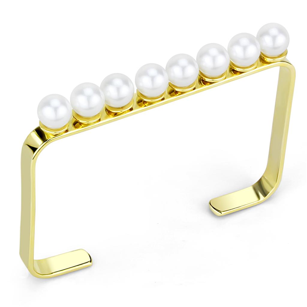 Gold brass bangle featuring a synthetic white pearl, elegantly designed for stylish wear.