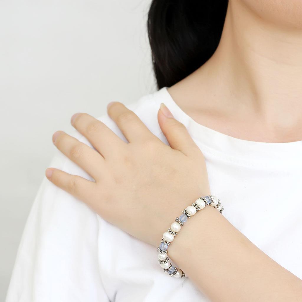 Antique silver white metal bracelet featuring a synthetic sea blue pearl, showcasing intricate design and craftsmanship.