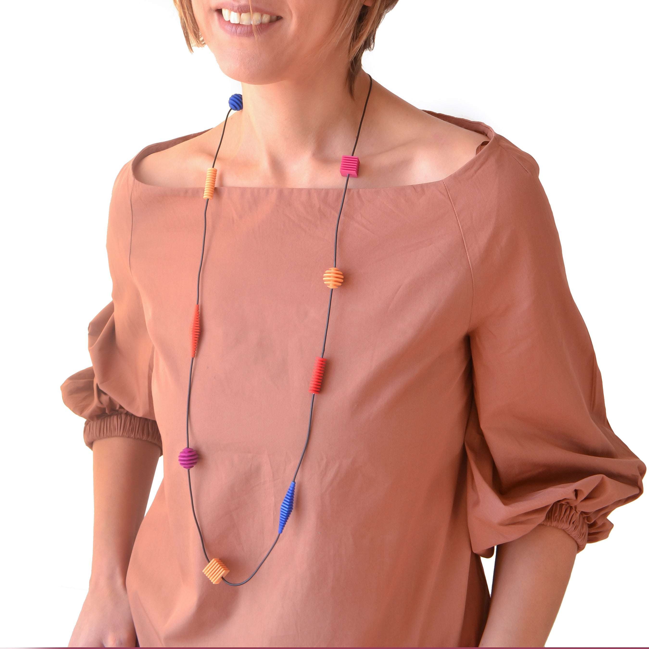 Long Beaded Optical Necklace featuring vibrant hand-dyed beads in geometric shapes, perfect for stylish outfits.