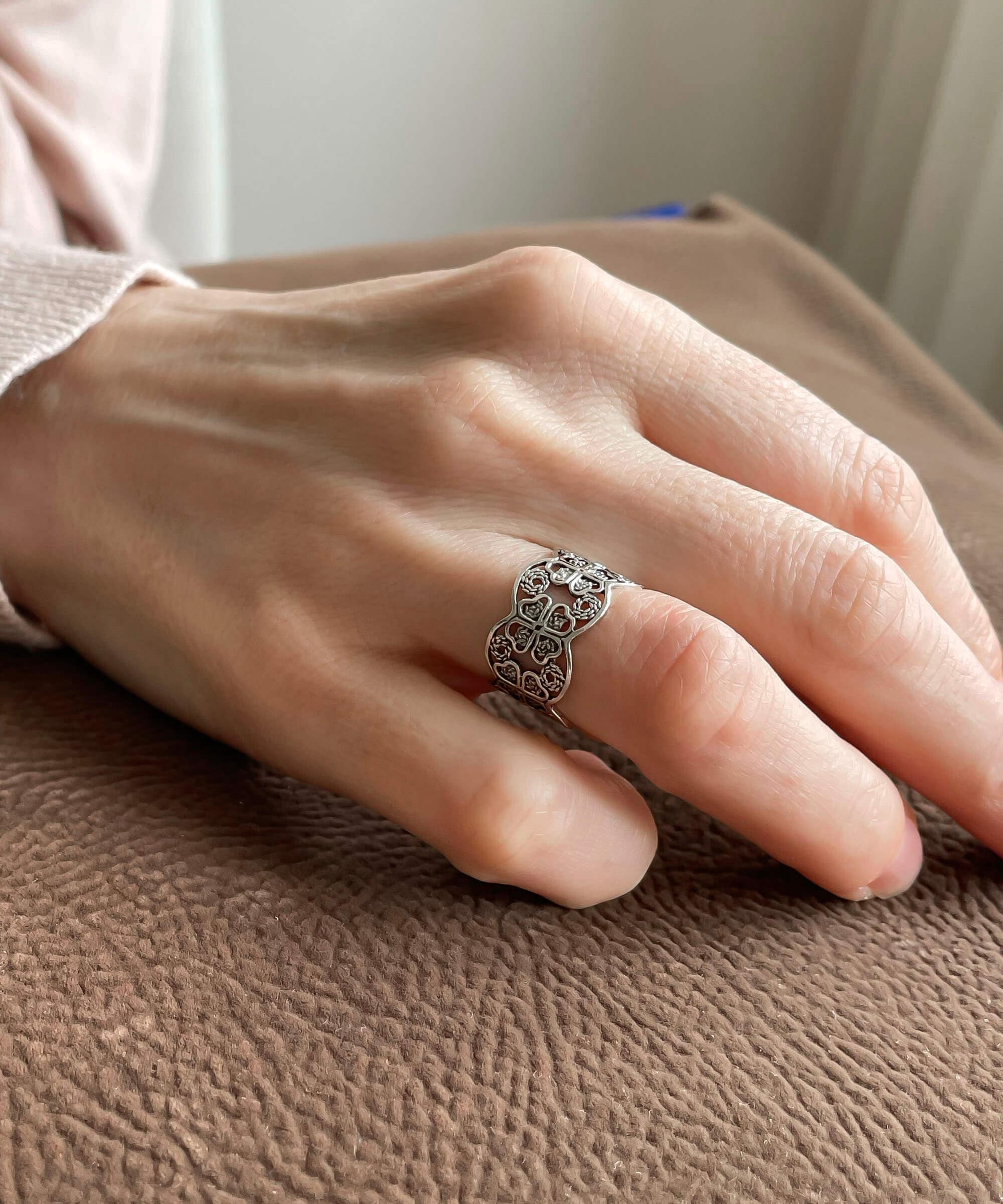 A stunning 925 sterling silver filigree art band ring featuring a four clover design, showcasing intricate metalwork and a polished finish.