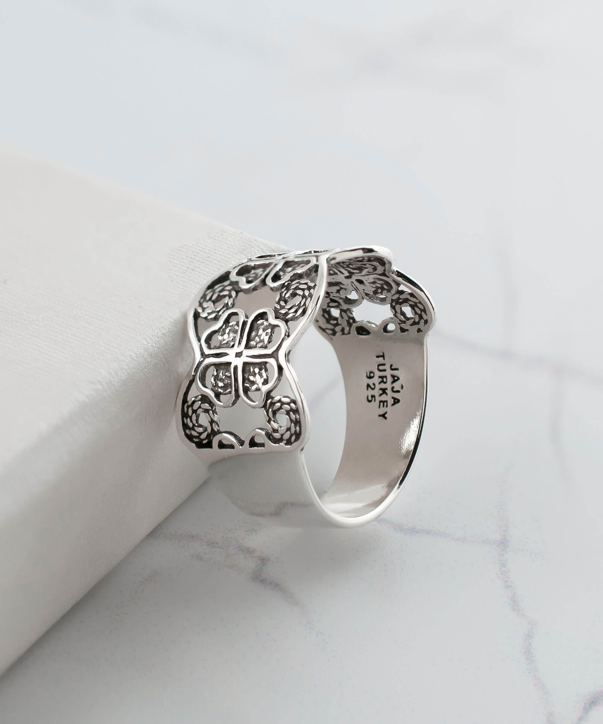 A stunning 925 sterling silver filigree art band ring featuring a four clover design, showcasing intricate metalwork and a polished finish.