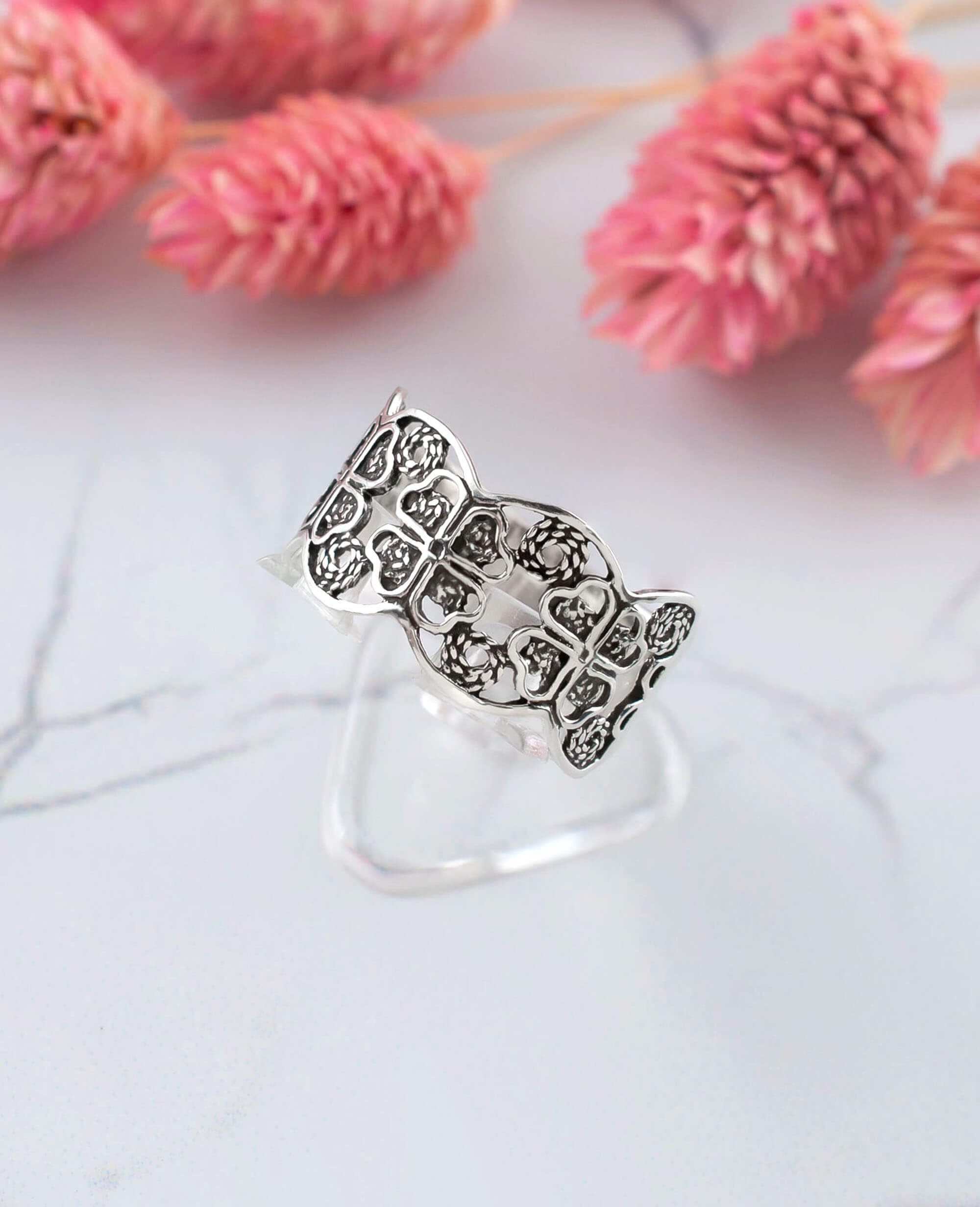 A stunning 925 sterling silver filigree art band ring featuring a four clover design, showcasing intricate metalwork and a polished finish.
