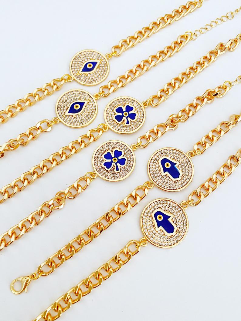 Lucky Evil Eye Bracelet featuring gold link chain and protective charms like Hamsa Hand and Clover, adorned with blue beads.