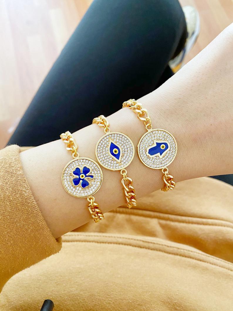 Lucky Evil Eye Bracelet featuring gold link chain and protective charms like Hamsa Hand and Clover, adorned with blue beads.