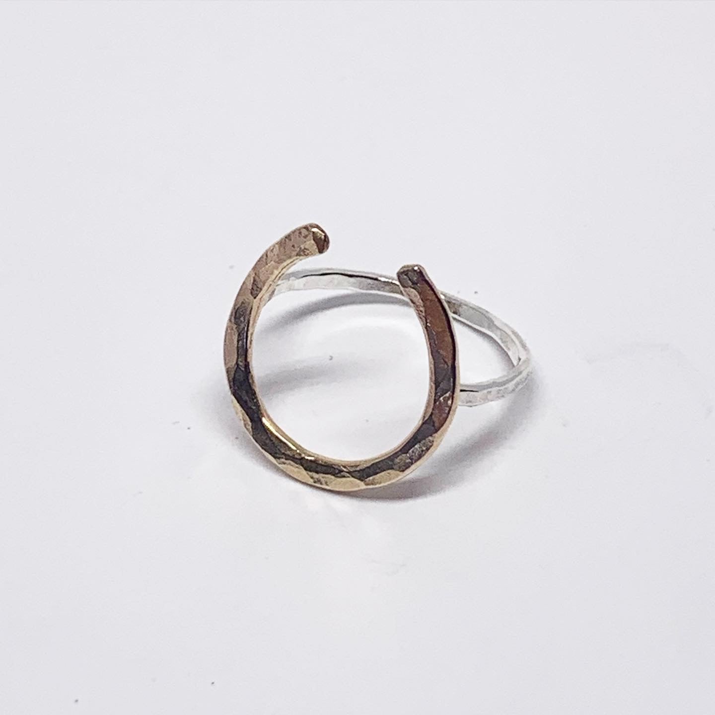 A large two-toned lucky horseshoe ring, handmade from recycled metals, featuring a sterling and gold design.