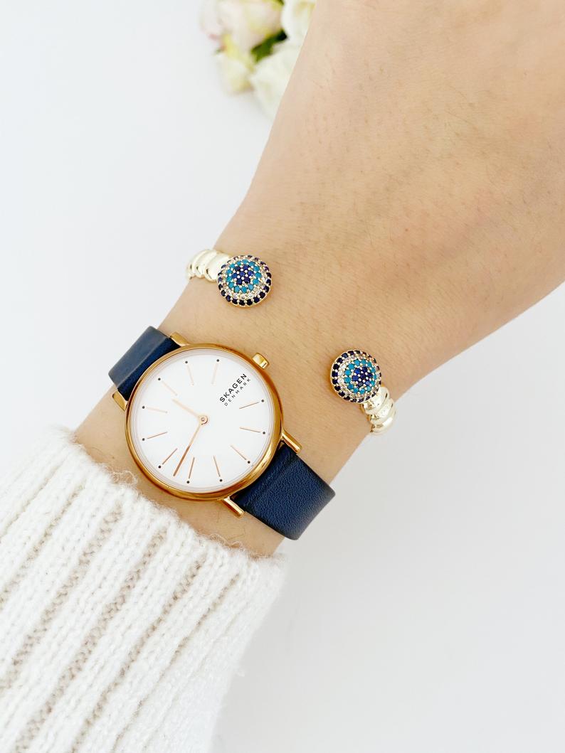 Luxury Evil Eye Bracelet featuring a gold twisted cuff and a movable zircon evil eye charm, showcasing its elegant design and adjustable fit.